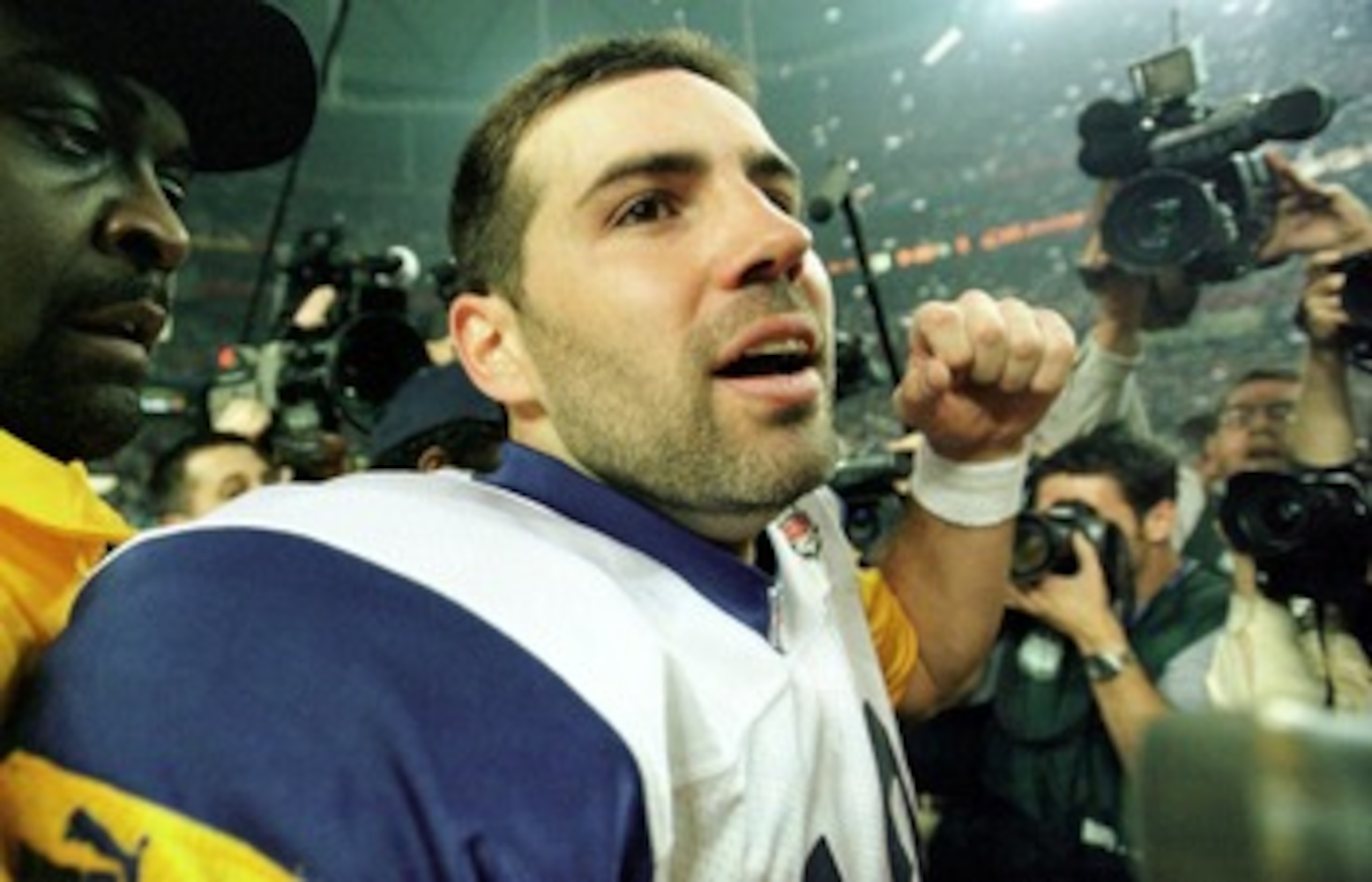 F363722 55: (NORTH AND SOUTH AMERICA SALES ONLY) Quarterback Kurt Warner of the St Louis Rams is escorted off the field after winning Super Bowl XXXIV at the Georgia Dome in Atlanta, Georgia on January 30, 2000. The St. Louis Rams defeated the Tennessee T