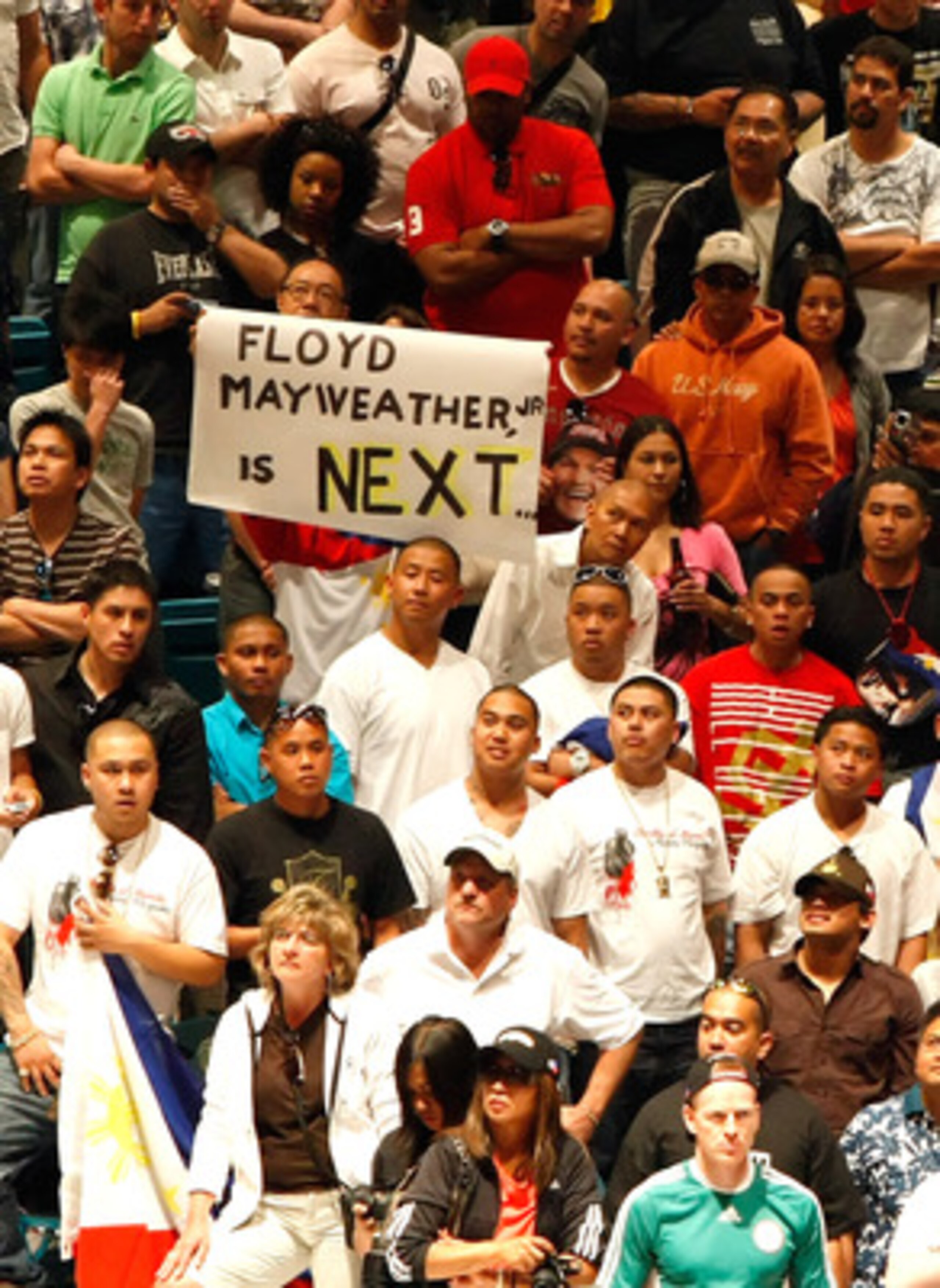 LAS VEGAS - MAY 01:  A sign for Floyd Mayweather Jr. is held as boxing fans wait for the official weigh-in for the junior welterweight title fight between Ricky Hatton of England and Manny Pacquiao of the Philippines at the MGM Grand Garden Arena May 1, 2