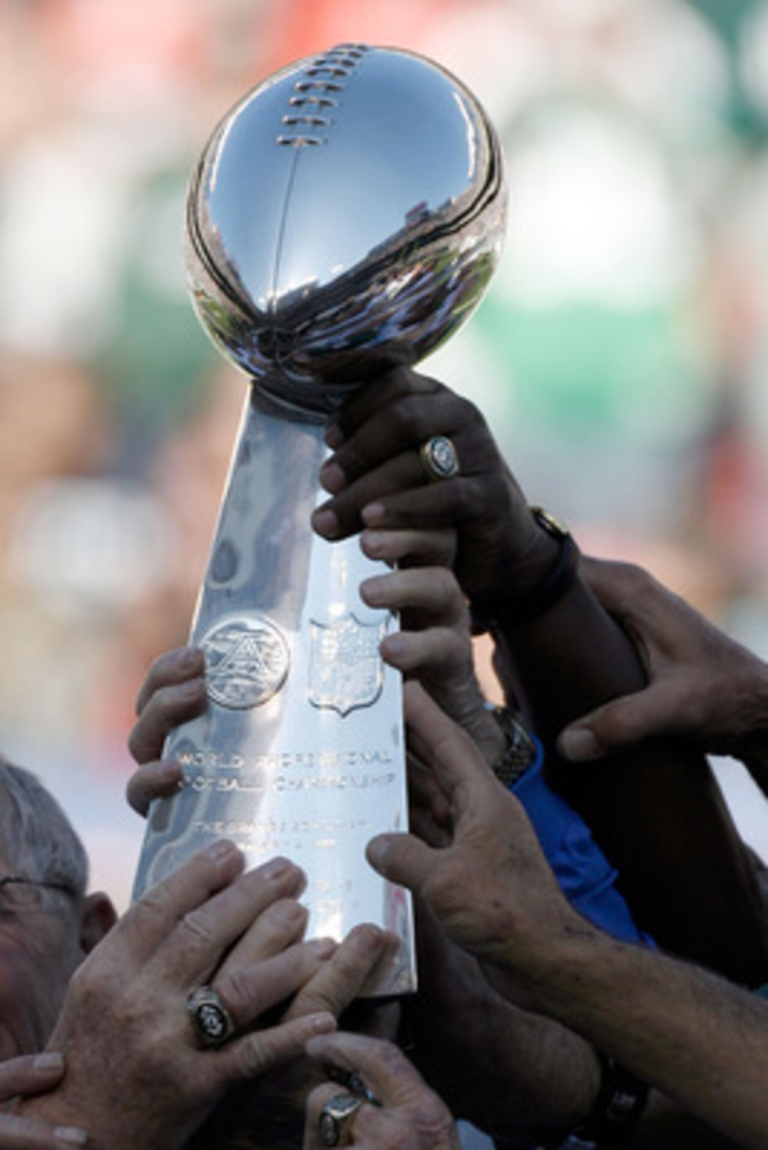 EAST RUTHERFORD, NJ - OCTOBER 26:  Members of the 1968 Jets touch the Lombardi Trophy during halftime festivities celebrating the 40th anniversary of the team's win over the Colts in Super Bowl III during the game between the Kansas City Chiefs and the Ne