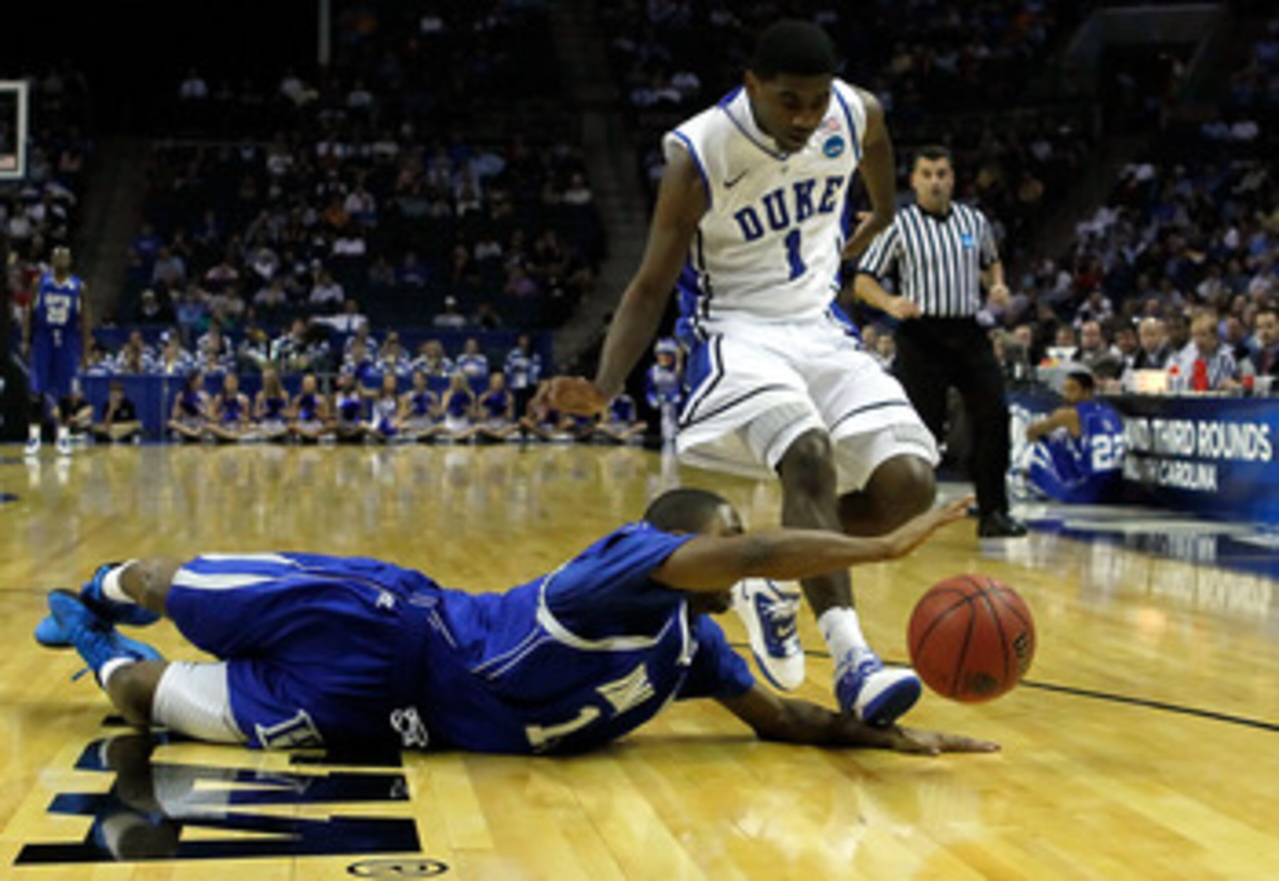 CHARLOTTE, NC - MARCH 18:  Mike Tuitt #11 of the Hampton Pirates drives for the ball in front of Kyrie Irving #1 of the Duke Blue Devils in the second half during the second round of the 2011 NCAA men's basketball tournament at Time Warner Cable Arena on 
