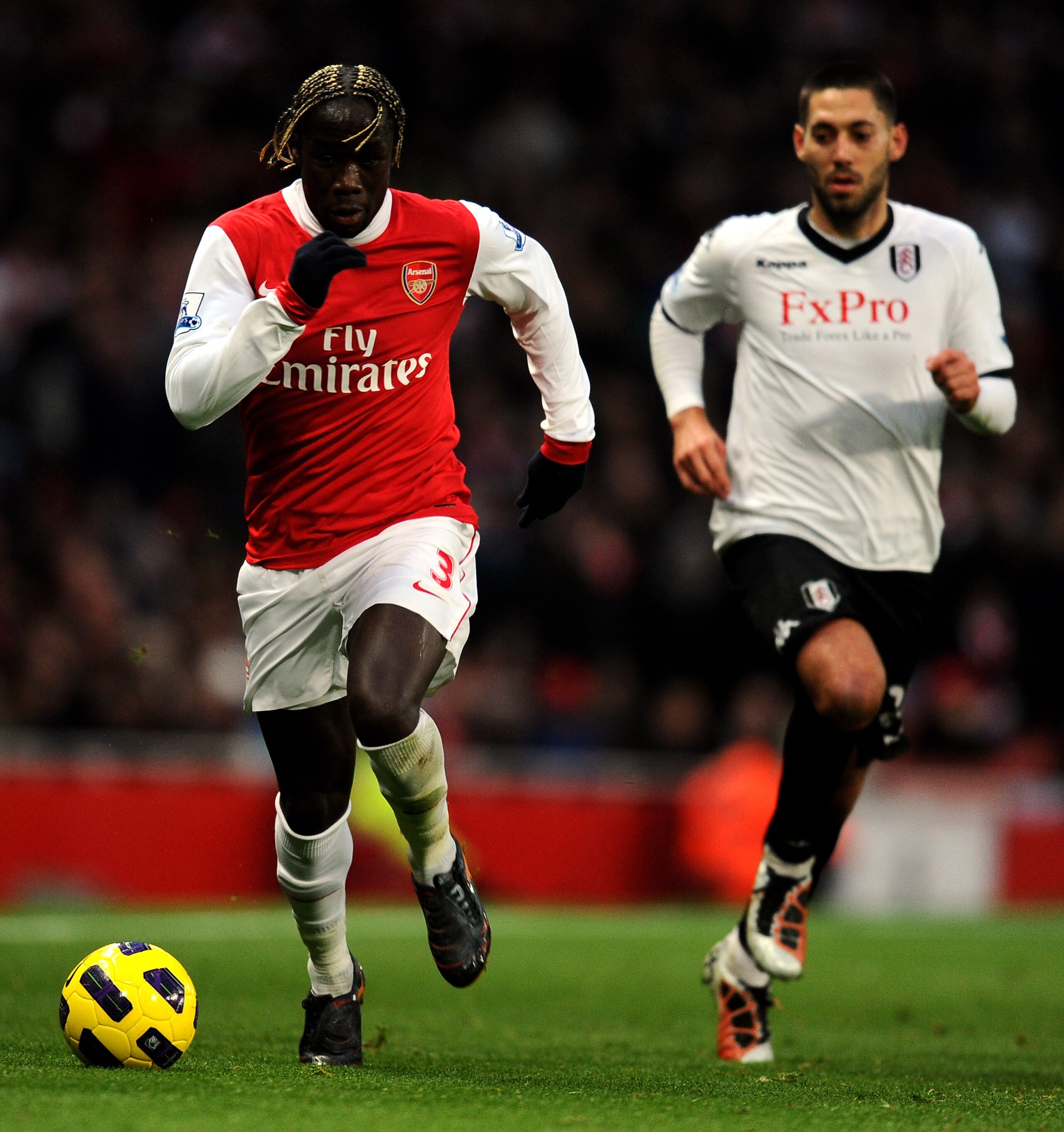 LONDON, ENGLAND - DECEMBER 04:  Bacary Sagna of Arsenal controls the ball under pressure from Clint Dempsey (R) of Fulham during the Barclays Premier League match between Arsenal and Fulham at the Emirates Stadium on December 4, 2010 in London, England.