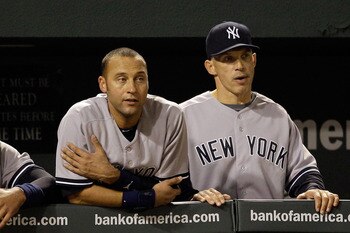 BALTIMORE, MD - APRIL 23:  Alex Rodriguez #13 of the New York Yankees (L) Derek Jeter #2 (C) and manager Joe Girardi #28 (R) look out from the dugout during the eighth inning of their 15-3 win over the Baltimore Orioles at Oriole Park at Camden Yards on A