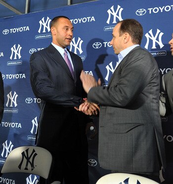 TAMPA, FL - DECEMBER 07:   Shortstop Derek Jeter of the New York Yankees (2L) shakes hands with General Manager Brian Cashman (2R) during a press conference to announce his new contract with the club on December 7, 2010 in Tampa, Florida.  (Photo by Tim B