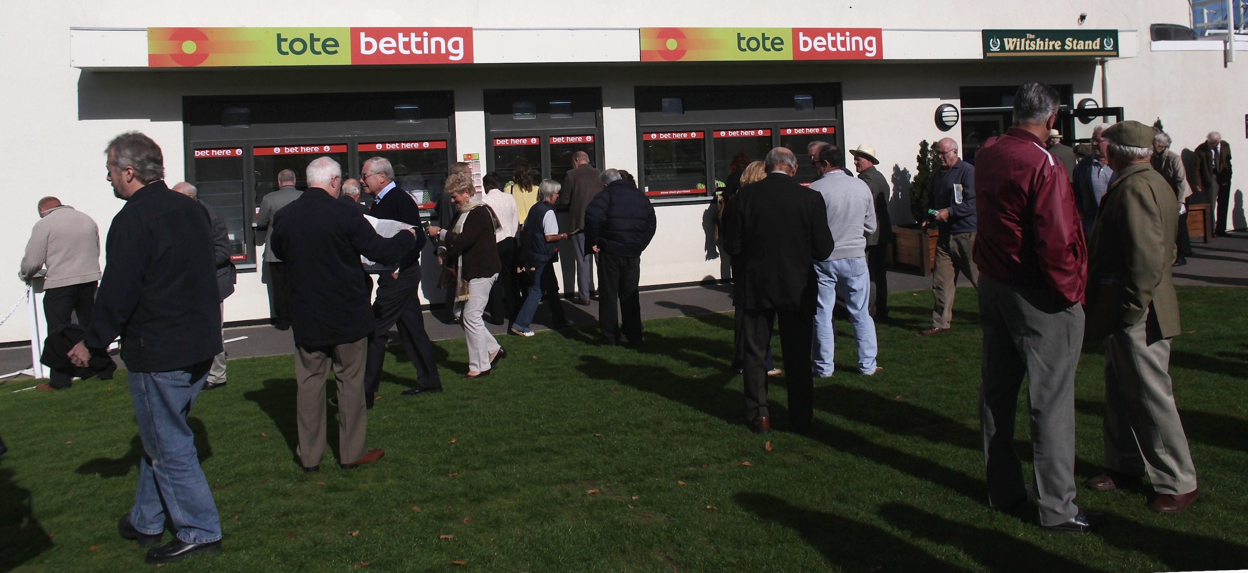 SALISBURY, ENGLAND - OCTOBER 12: Racegoers gather outside a Tote betting window before the first race to be run at Salisbury Racecourse on October 12, 2009 in Salisbury, England. Prime Minister Gordon Brown is expected to announce the sale of GBP £16 bill