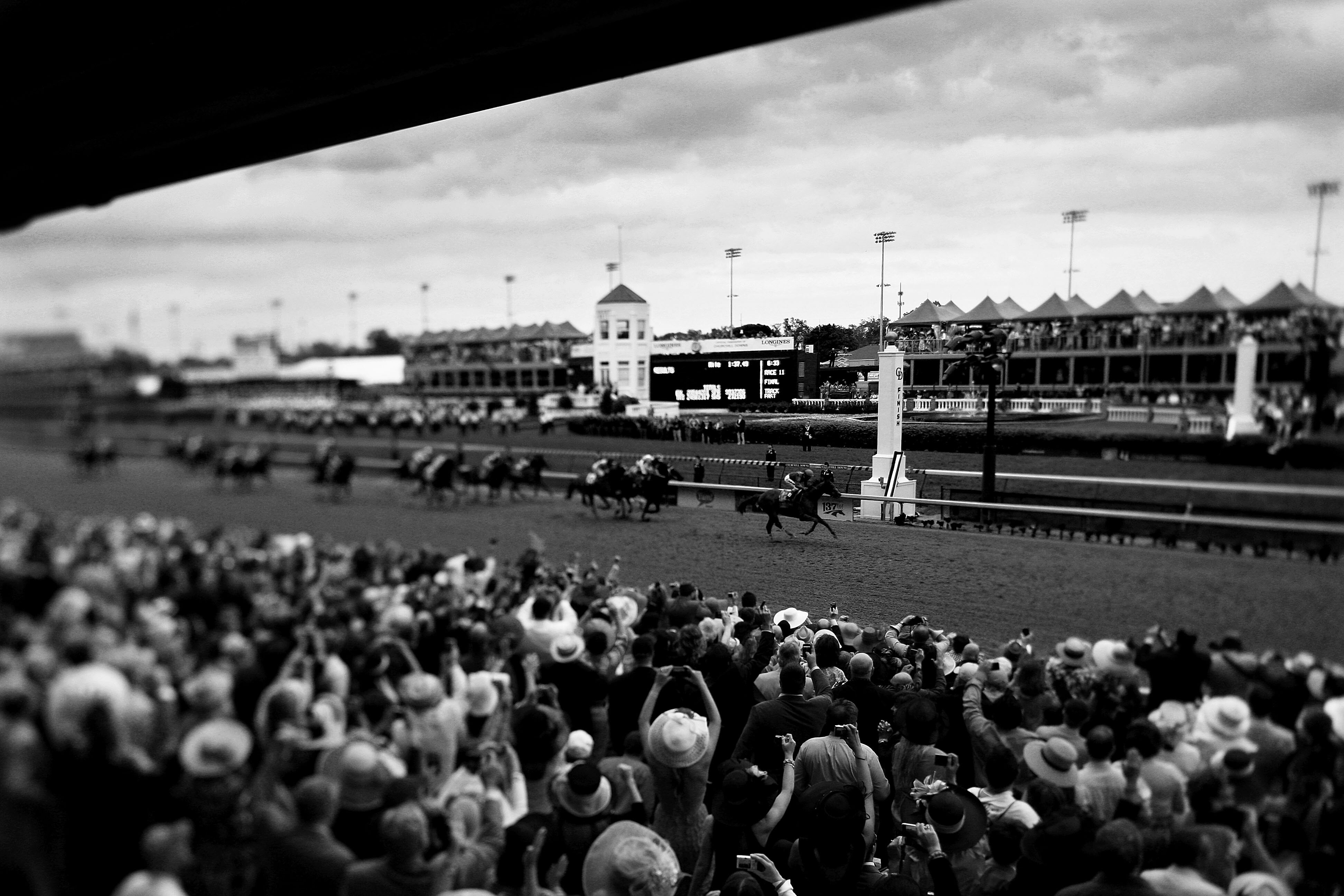 LOUISVILLE, KY - MAY 07:  (EDITORS NOTE: A VARIABLE FOCAL PLANE LENSE WAS USED AND WAS CONVERTED TO BLACK AND WHITE)  Jockey John Velazquez, riding Animal Kingdom #16 crosses the finish line to win the 137th Kentucky Derby at Churchill Downs on May 7, 201