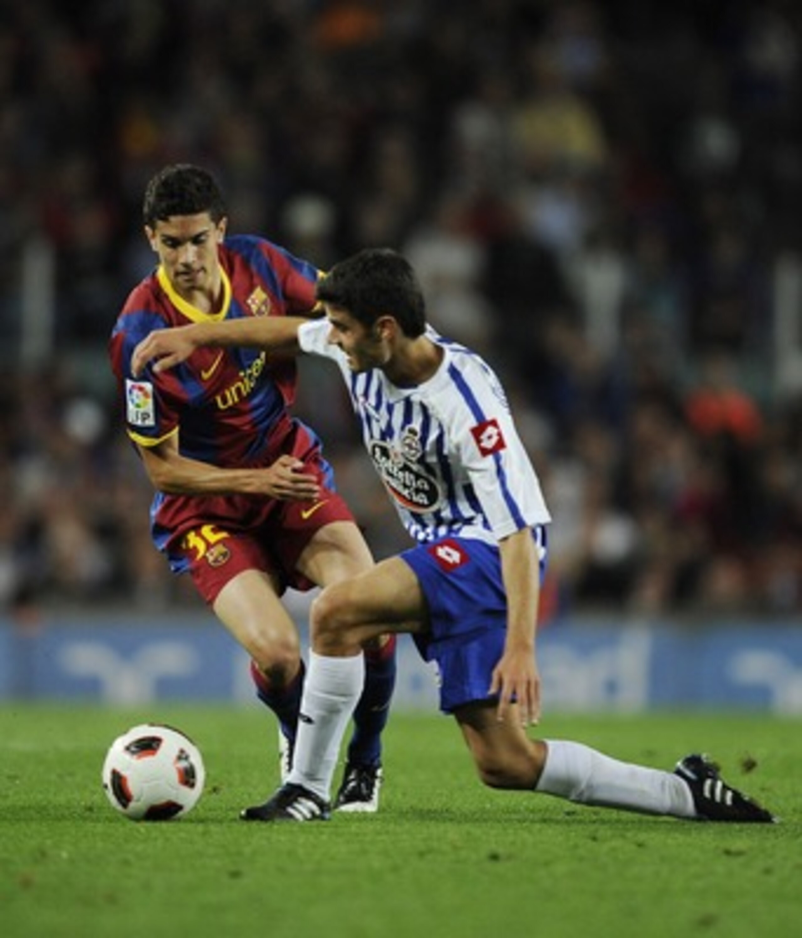 BARCELONA, SPAIN - MAY 15:  Bartra (L) of FC Barcelona competes for the ball against Juan Dominguez of Deportivo La Coruna during the La Liga match between Barcelona and Deportivo La Coruna at Camp Nou Stadium on May 15, 2011 in Barcelona, Spain.  (Photo