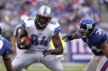 EAST RUTHERFORD, NJ - OCTOBER 17: Brandon Pettigrew #84 of the Detroit Lions runs with the ball under pressure from Deon Grant #34 of the New York Giants at New Meadowlands Stadium on October 17, 2010 in East Rutherford, New Jersey.  (Photo by Nick Laham/