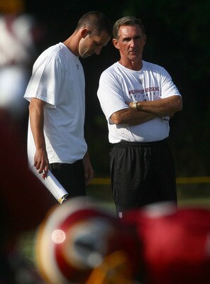 ASHBURN, VA - JULY 30:  Head coach Mike Shanahan (R) of the Washington Redskins speaks with his son and offensive coordinator, Kyle Shanahan (L), during the second day of training camp July 30, 2010 in Ashburn, Virginia.  (Photo by Win McNamee/Getty Image
