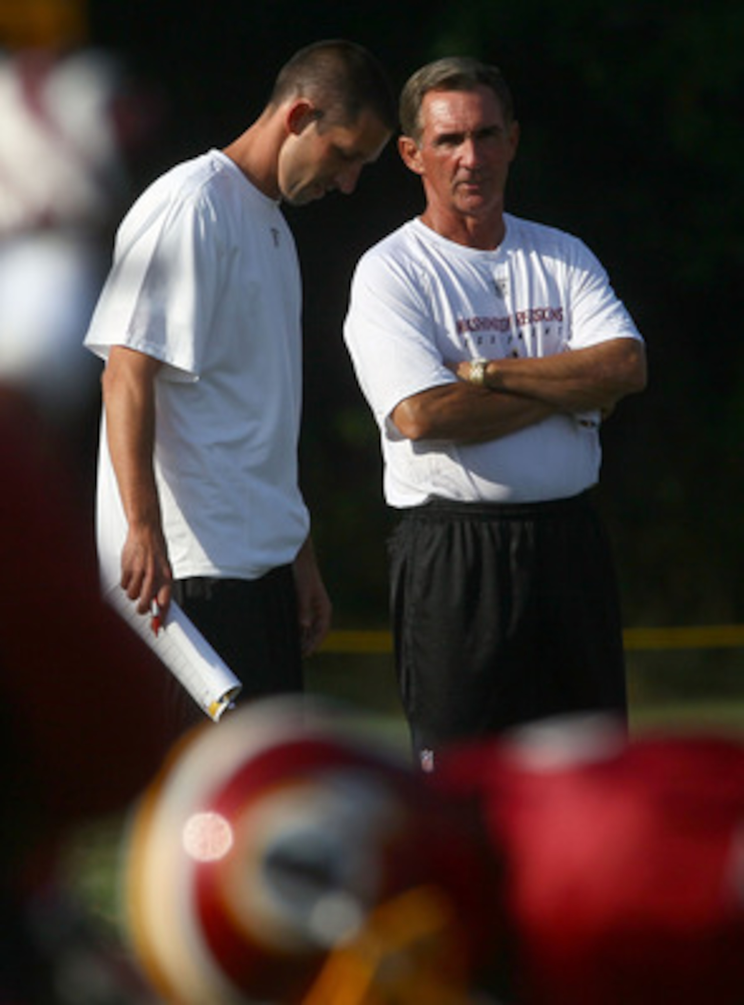 ASHBURN, VA - JULY 30:  Head coach Mike Shanahan (R) of the Washington Redskins speaks with his son and offensive coordinator, Kyle Shanahan (L), during the second day of training camp July 30, 2010 in Ashburn, Virginia.  (Photo by Win McNamee/Getty Image