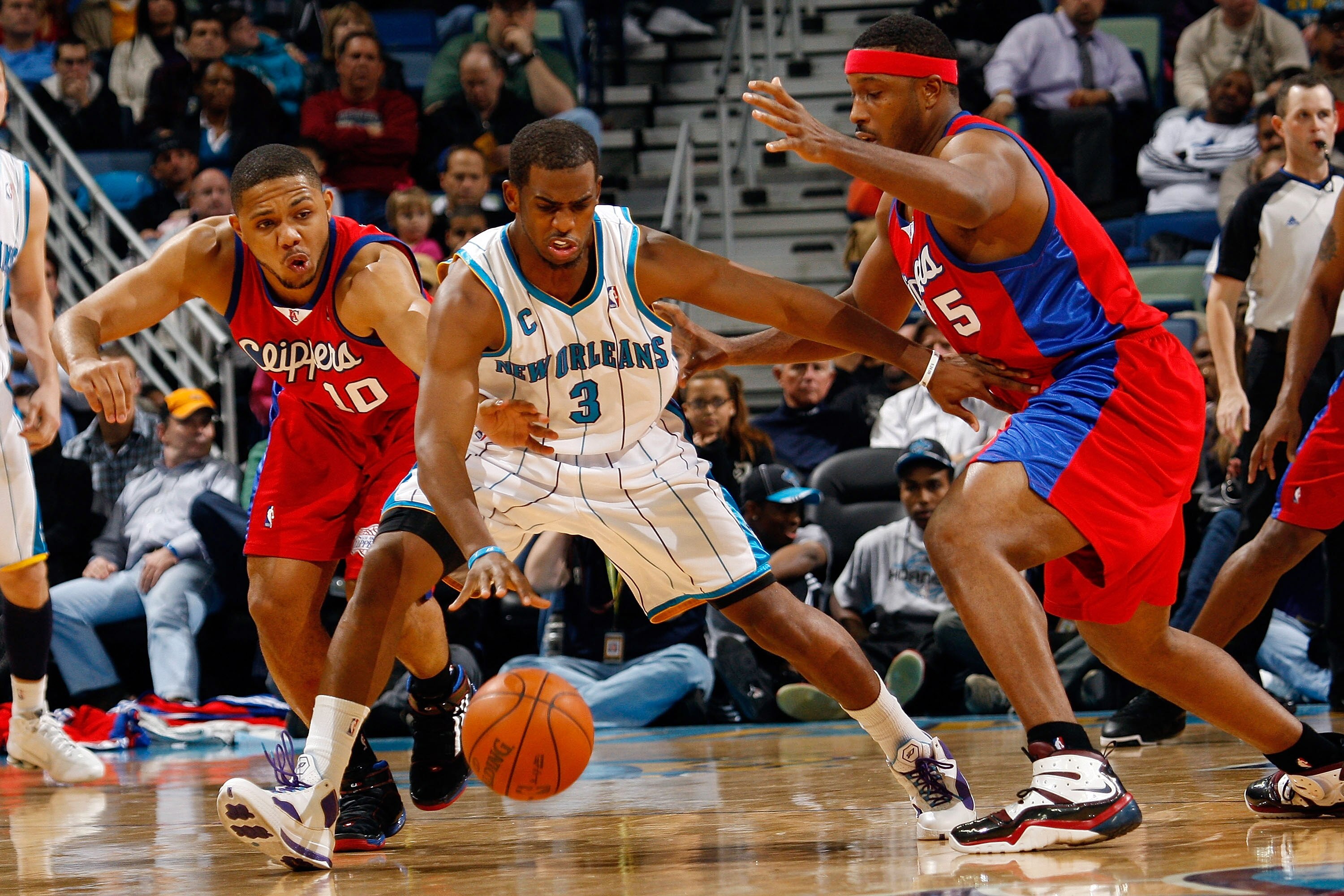 NEW ORLEANS - JANUARY 13:  Chris Paul #3 of the New Orleans Hornets fights to keep the ball away from Eric Gordon #12 and Craig Smith #5 of the Los Angeles Clippers at the New Orleans Arena on January 13, 2010 in New Orleans, Louisiana.  The Hornets defea