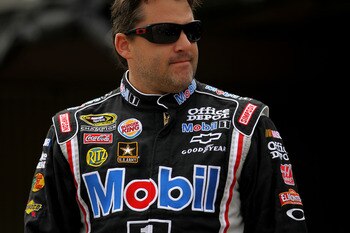 DOVER, DE - MAY 13:  Tony Stewart, driver of the #14 Mobil 1/Office Depot Chevrolet, walks in the garage area during practice for the NASCAR Sprint Cup Series FedEx 400 Benefiting Autism Speaks at Dover International Speedway on May 13, 2011 in Dover, Del
