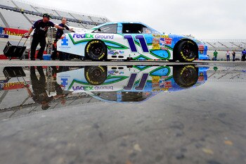 DOVER, DE - MAY 15:  Crew members push the #11 FedEx Ground /Autism Speaks Toyota, driven by Denny Hamlin (not pictured), to inspection prior to the NASCAR Sprint Cup Series FedEx 400 Benefiting Autism Speaks at Dover International Speedway on May 15, 201