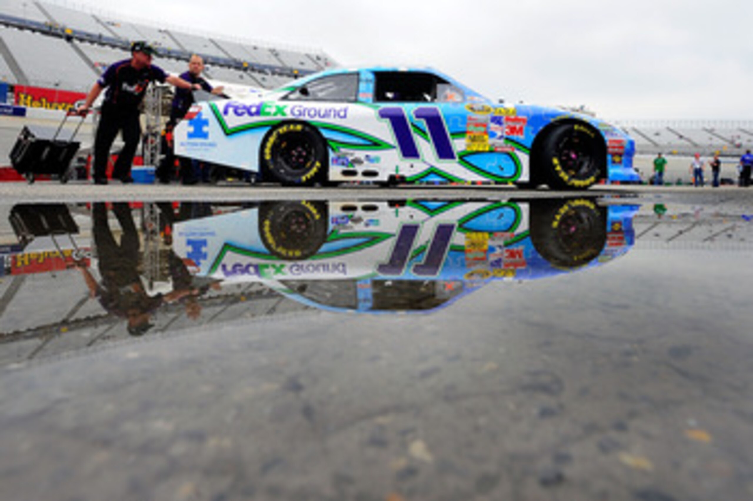 DOVER, DE - MAY 15: Crew members push the #11 FedEx Ground /Autism Speaks Toyota, driven by Denny Hamlin (not pictured), to inspection prior to the NASCAR Sprint Cup Series FedEx 400 Benefiting Autism Speaks at Dover International Speedway on May 15, 201 DOVER, DE - MAY 15: Crew members push the #11 FedEx Ground /Autism Speaks Toyota, driven by Denny Hamlin (not pictured), to inspection prior to the NASCAR Sprint Cup Series FedEx 400 Benefiting Autism Speaks at Dover International Speedway on May 15, 201