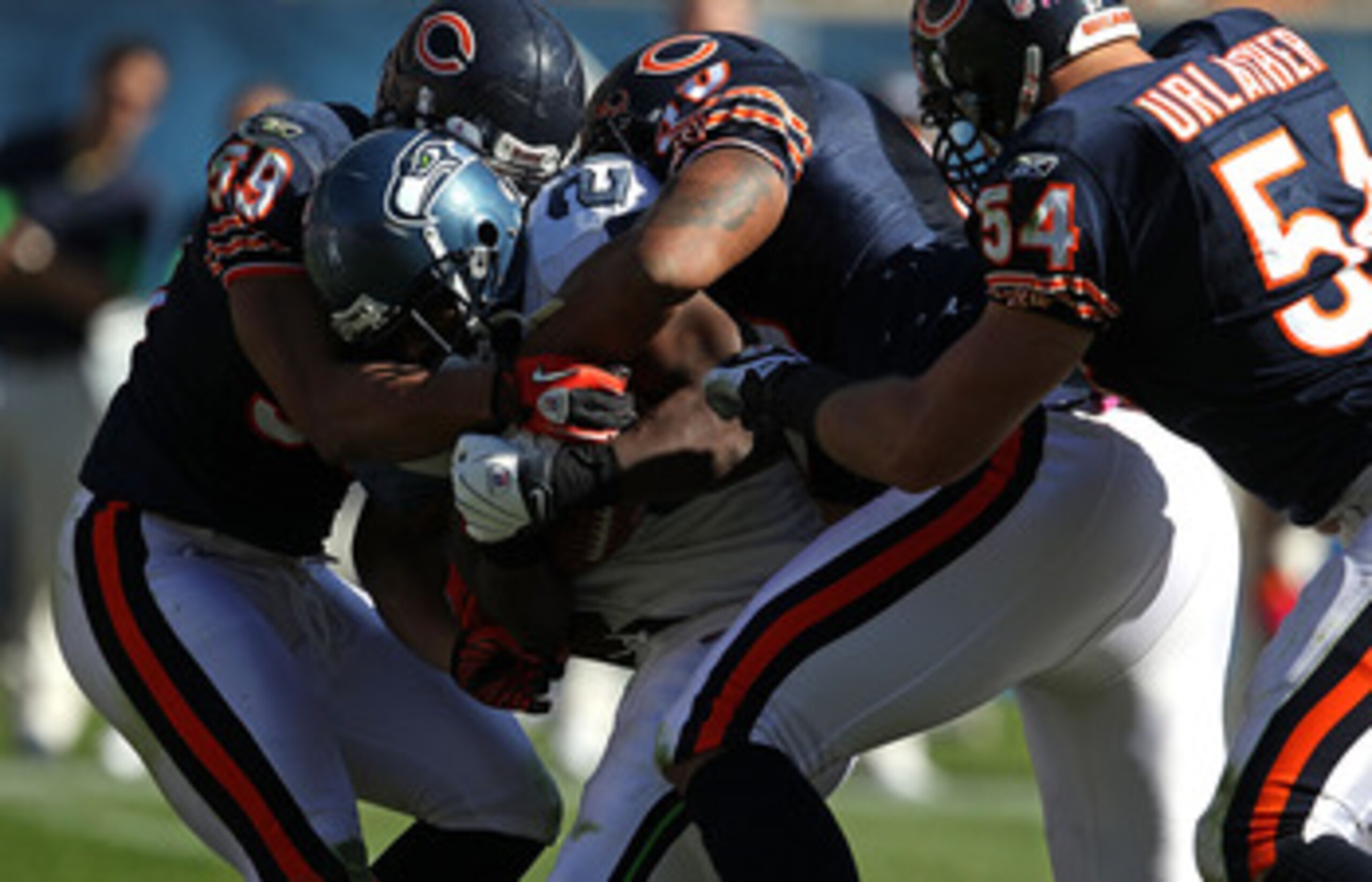 CHICAGO - OCTOBER 17: Justin Forsett #20 of the Seattle Seahawks is tackled by (L-R) Pia Tinoisamoa #59, Julius Peppers #90 and Brian Urlacher #54 of the Chicago Bears at Soldier Field on October 17, 2010 in Chicago, Illinois. The Seahawks defeated the Be