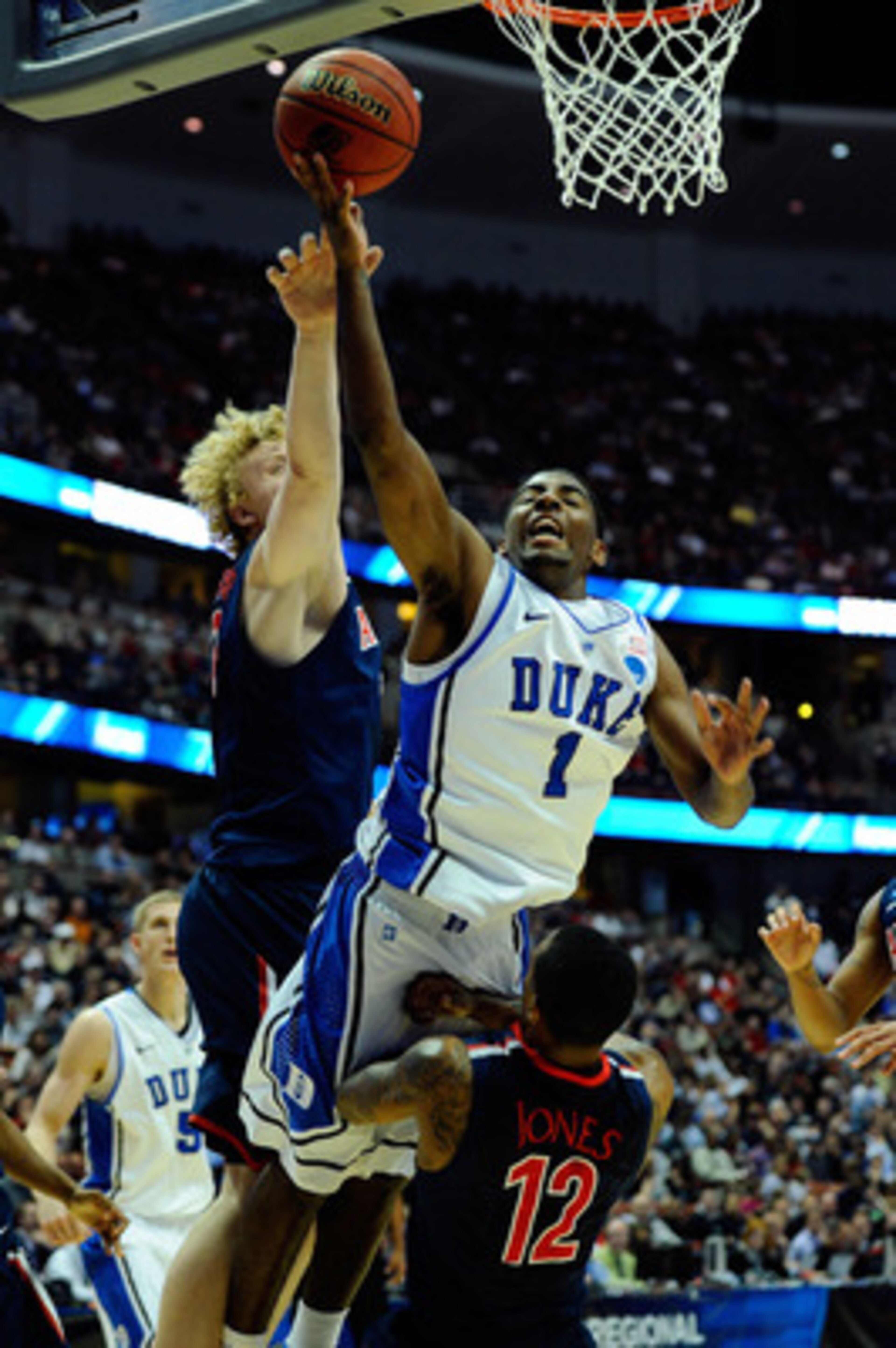 ANAHEIM, CA - MARCH 24: Kyrie Irving #1 of the Duke Blue Devils draws contact against Kyryl Natyazhko #1 and Lamont Jones #12 of the Arizona Wildcats during the west regional semifinal of the 2011 NCAA men's basketball tournament at the Honda Center on M ANAHEIM, CA - MARCH 24: Kyrie Irving #1 of the Duke Blue Devils draws contact against Kyryl Natyazhko #1 and Lamont Jones #12 of the Arizona Wildcats during the west regional semifinal of the 2011 NCAA men's basketball tournament at the Honda Center on M