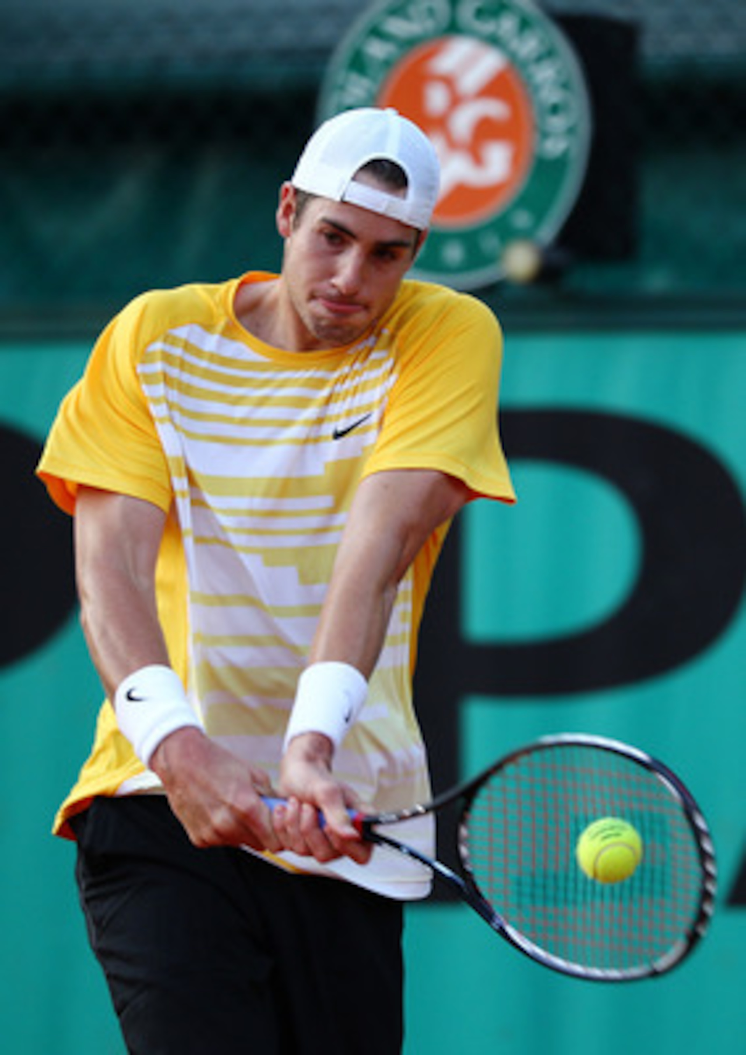 PARIS - MAY 26:  John Isner of the United States hits a backhand during the men's singles second round match between John Isner of the United States and Marco Chiudinelli of Switzerland on day four of the French Open at Roland Garros on May 26, 2010 in Pa