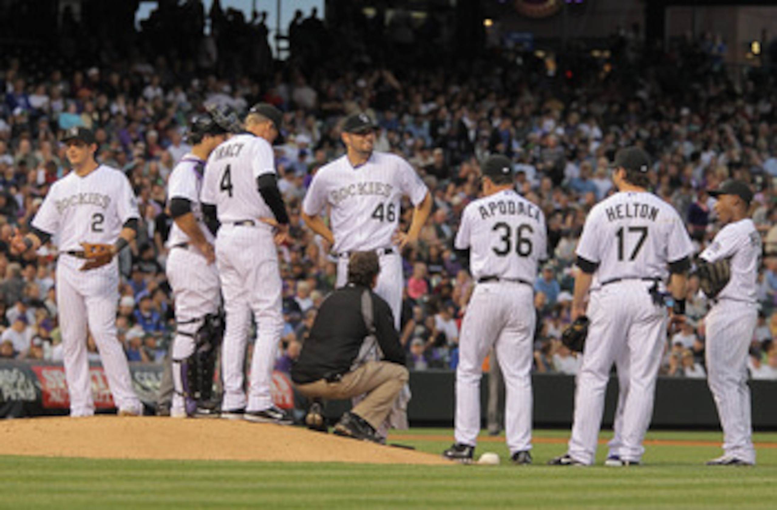 DENVER, CO - MAY 10:  Assistant trainer Scott Gehret attends to starting pitcher Jason Hammel #46 of the Colorado Rockies after he was hit in the leg by a line drive by Ronny Paulino #9 of the New York Mets in the fourth inning at Coors Field on May 10, 2