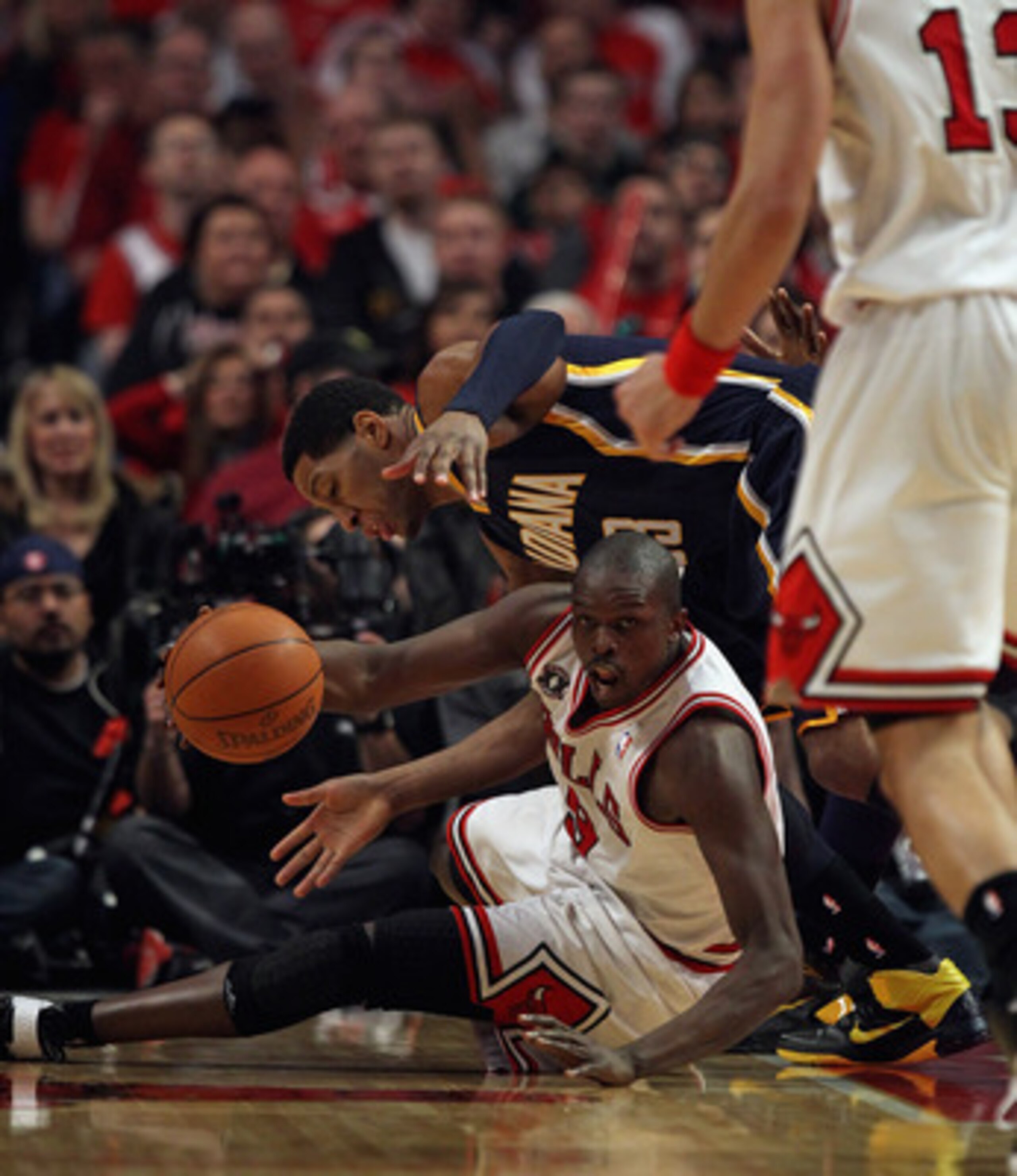 CHICAGO, IL - APRIL 16: Loul Deng #9 of the Chicago Bulls looks to pass the ball to teammate Joakim Noah #13 under pressure from Danny Granger #33 of the Indiana Pacers in Game One of the Eastern Conference Quarterfinals in the 2011 NBA Playoffs at the Un