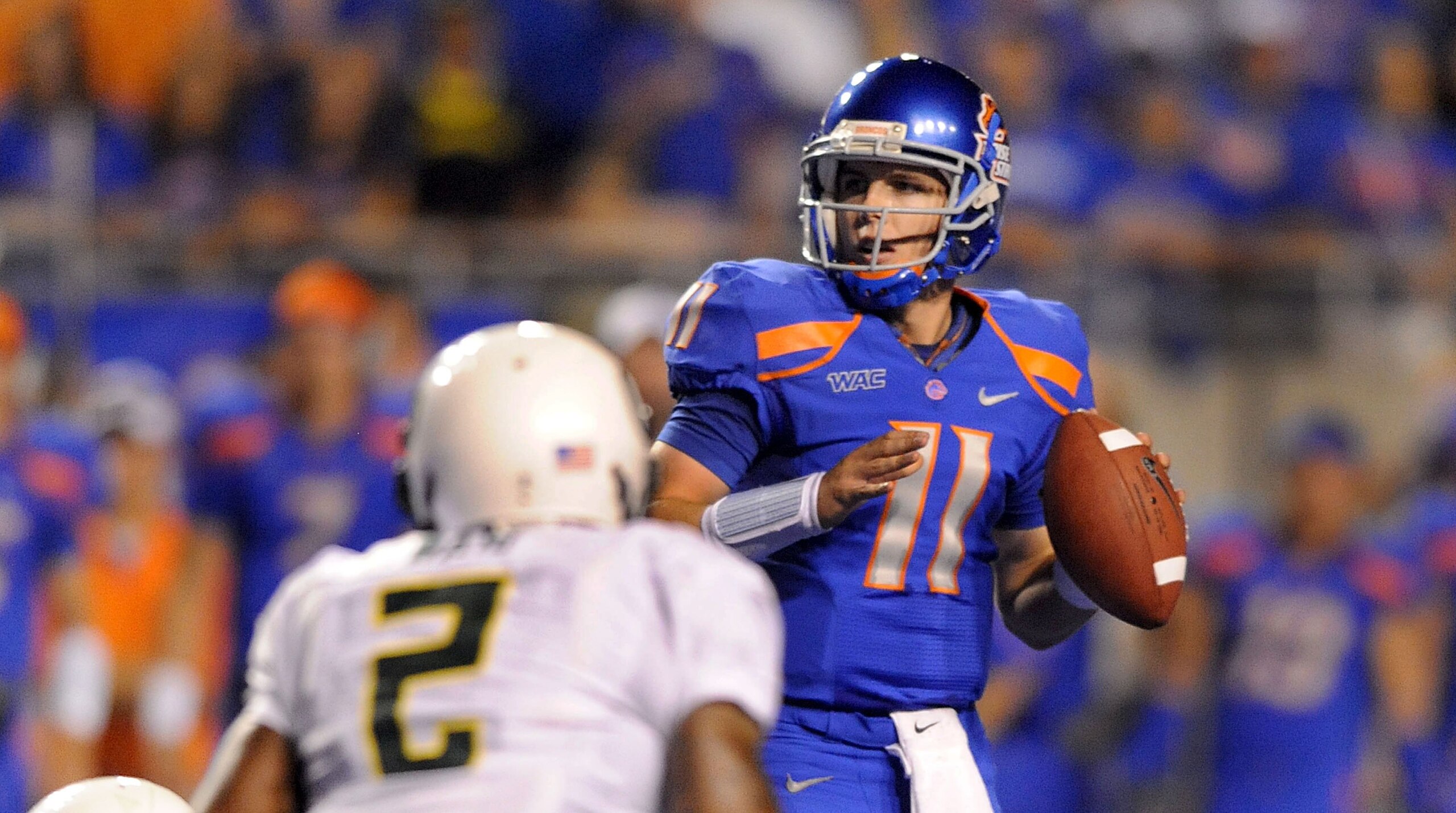 BOISE, ID - SEPTEMBER 3: Quarterback Kellen Moore #6 of the Boise State Broncos looks down field for an open receiver as safety T.J. Ward #2 of the Oregon Ducks applies pressure in the third quarter of the game at Bronco Stadium on September 3, 2009 in Bo