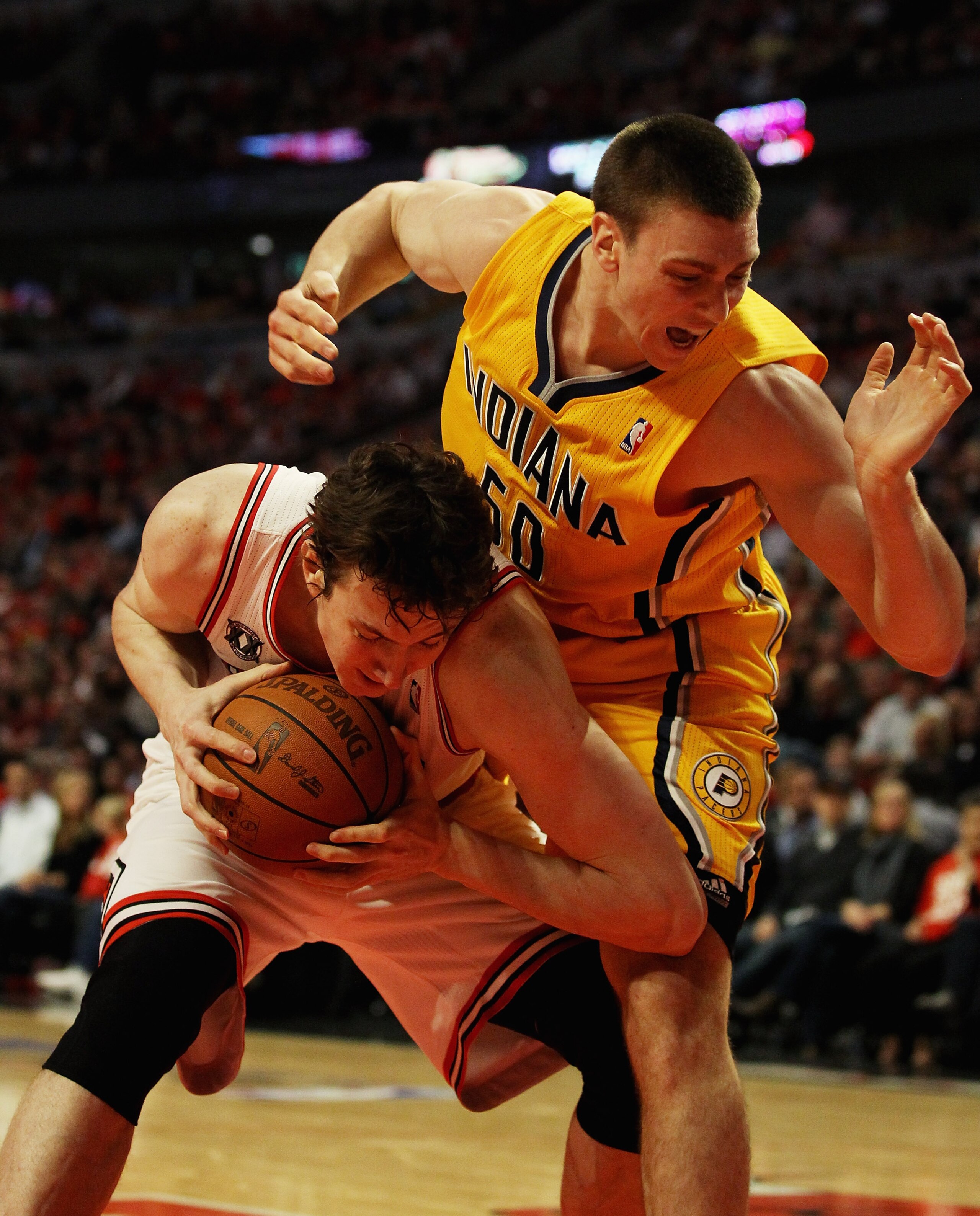 CHICAGO, IL - APRIL 26: Tyler Hansbrough #50 of the Indiana Pacers lands on Omer Asik #3 of the Chicago Bulls after Asik grabbed a rebound in Game Five of the Eastern Conference Quarterfinals in the 2011 NBA Playoffs at the United Center on April 26, 2011