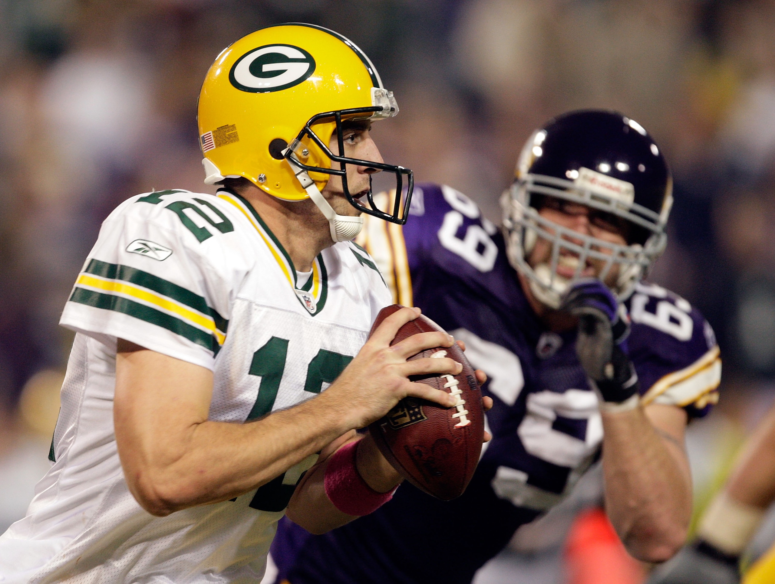 MINNEAPOLIS - OCTOBER 05:  Quarterback Aaron Rodgers #12 of the Green Bay Packers is chased by Jared Allen #69 of the Minnesota Vikings during the Monday Night Football game on October 5, 2009 at Hubert H. Humphrey Metrodome in Minneapolis, Minnesota.  (P