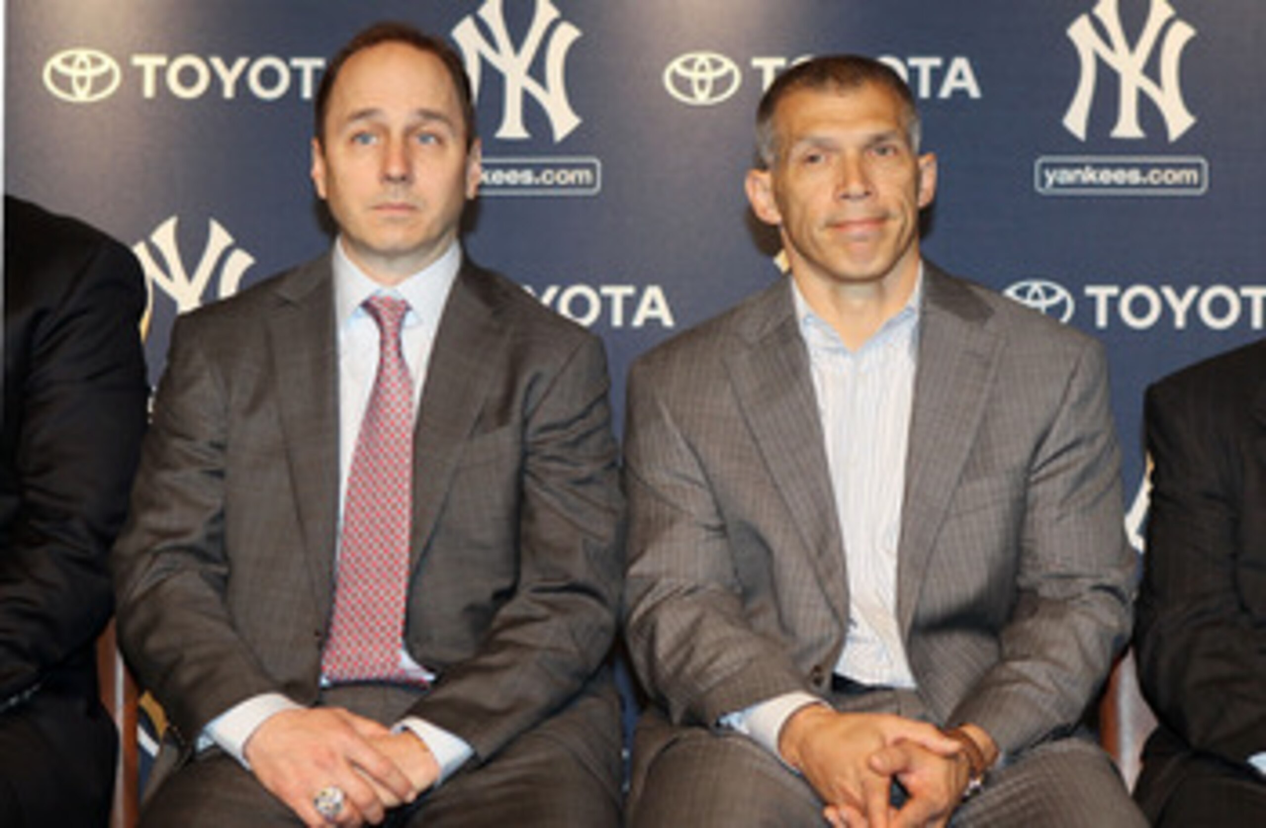 NEW YORK, NY - JANUARY 19:  General manager Brian Cashman (L) and manager Joe Girardi of the New York Yankees listen as Rafael Soriano (not pictured) speaks during his introduction press conference on January 19, 2011 at Yankee Stadium in the Bronx boroug