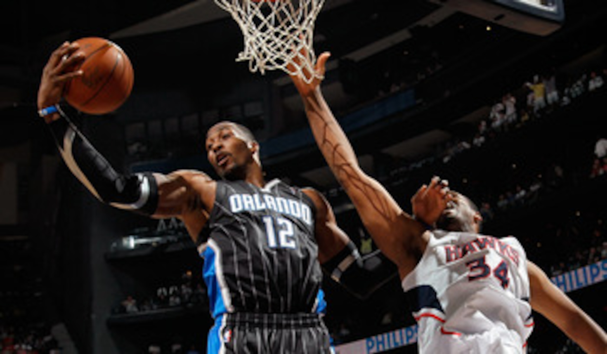 ATLANTA, GA - APRIL 24:  Dwight Howard #12 of the Orlando Magic grabs a rebound against Jason Collins #34 of the Atlanta Hawks during Game Four of the Eastern Conference Quarterfinals in the 2011 NBA Playoffs at Philips Arena on April 24, 2011 in Atlanta,