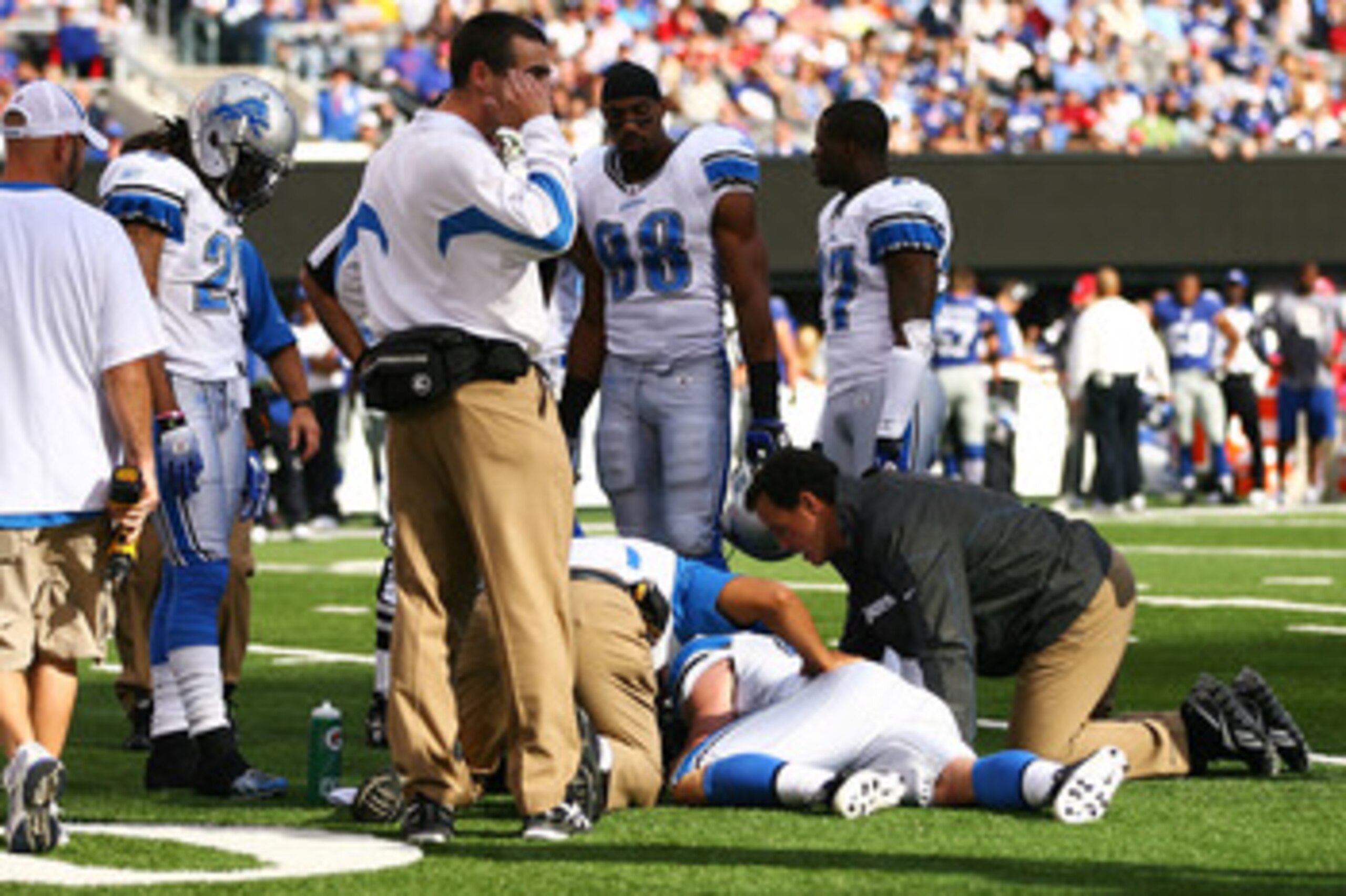 EAST RUTHERFORD, NJ - OCTOBER 17: Coaches check up on Zack Follett #49 of the Detroit Lions after he was injured during a punt return during a game against the New York Giants at New Meadowlands Stadium on October 17, 2010 in East Rutherford, New Jersey.