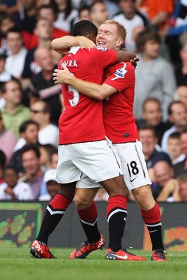 LONDON, ENGLAND - AUGUST 22:  Paul Scholes of Manchester United celebrates with Patrice Evra as he scores their first goal during the Barclays Premier League match between Fulham and Manchester United at Craven Cottage on August 22, 2010 in London, Englan