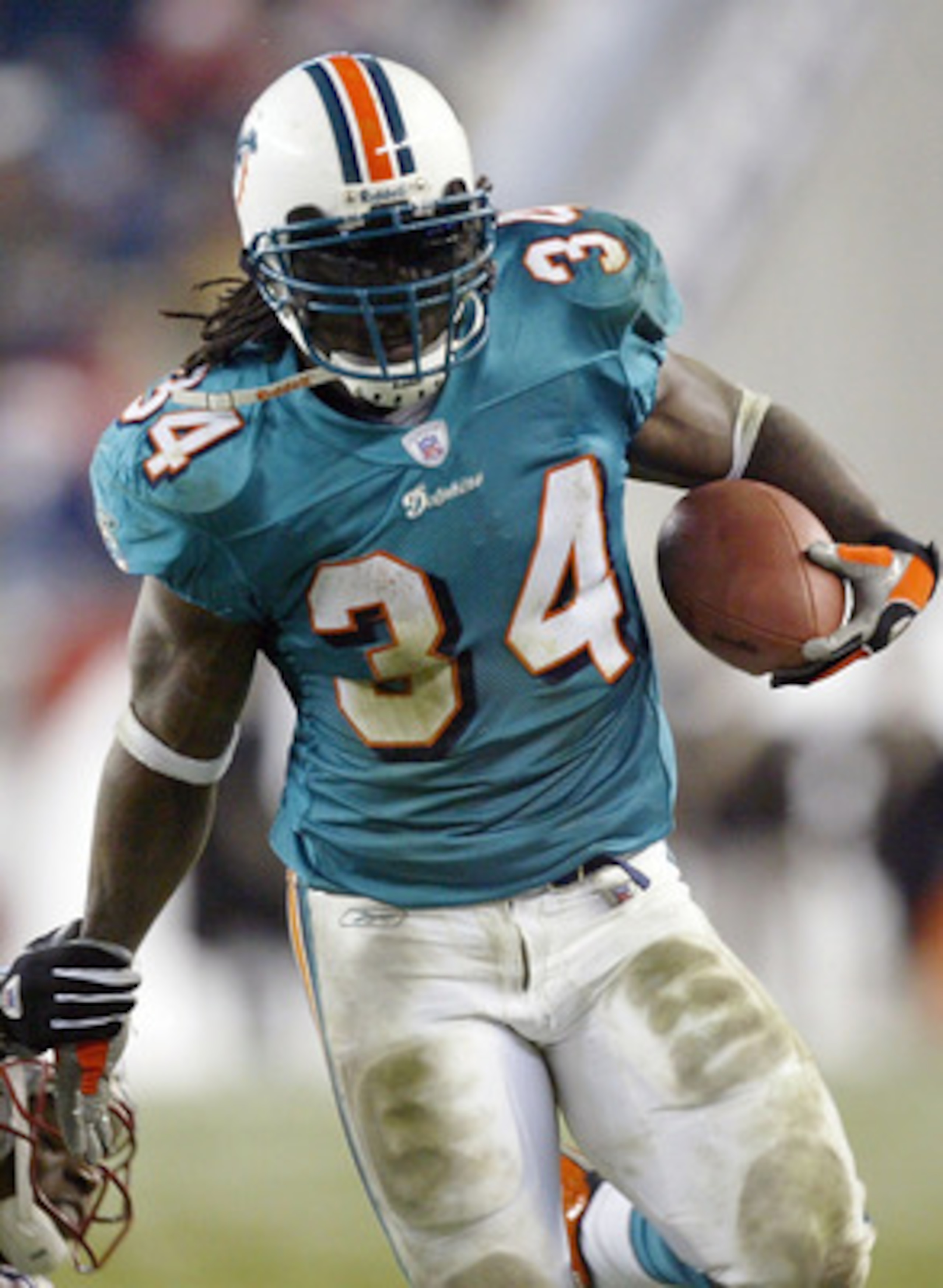 FOXBORO, MA - DECEMBER 7:  Ricky Williams #34 of the Miami Dolphins tries to avoid tacklers from the New England Patriots on December 7, 2003 at Gillette Stadium in Foxboro, Massachusetts. The Patriots won 12-0. (Photo by Ezra Shaw/Getty Images)