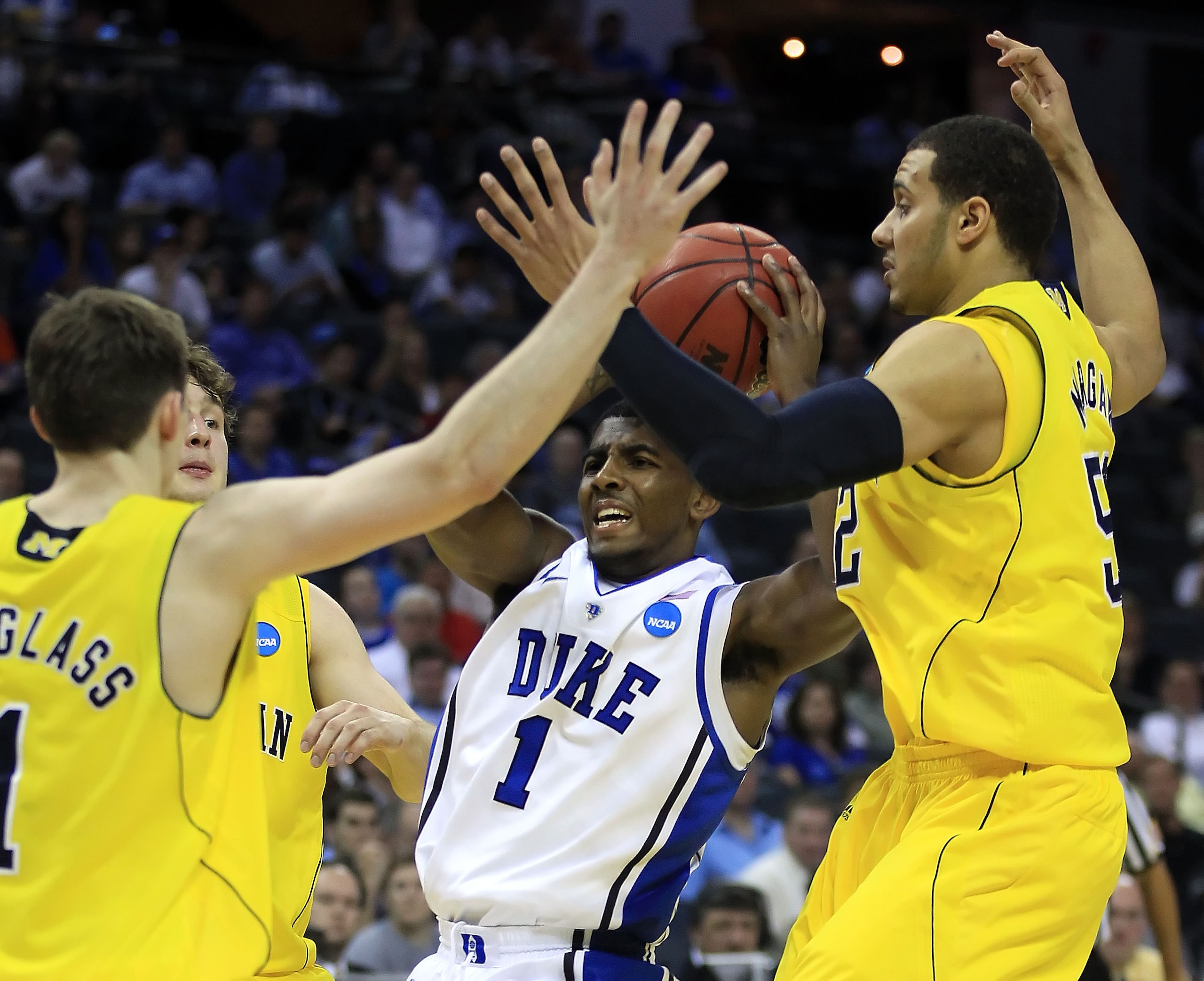 CHARLOTTE, NC - MARCH 20:  Kyrie Irving #1 of the Duke Blue Devils drives the ball against Stu Douglass #1 and Jordan Morgan #52 of the Michigan Wolverines during the third round of the 2011 NCAA men's basketball tournament at Time Warner Cable Arena on M