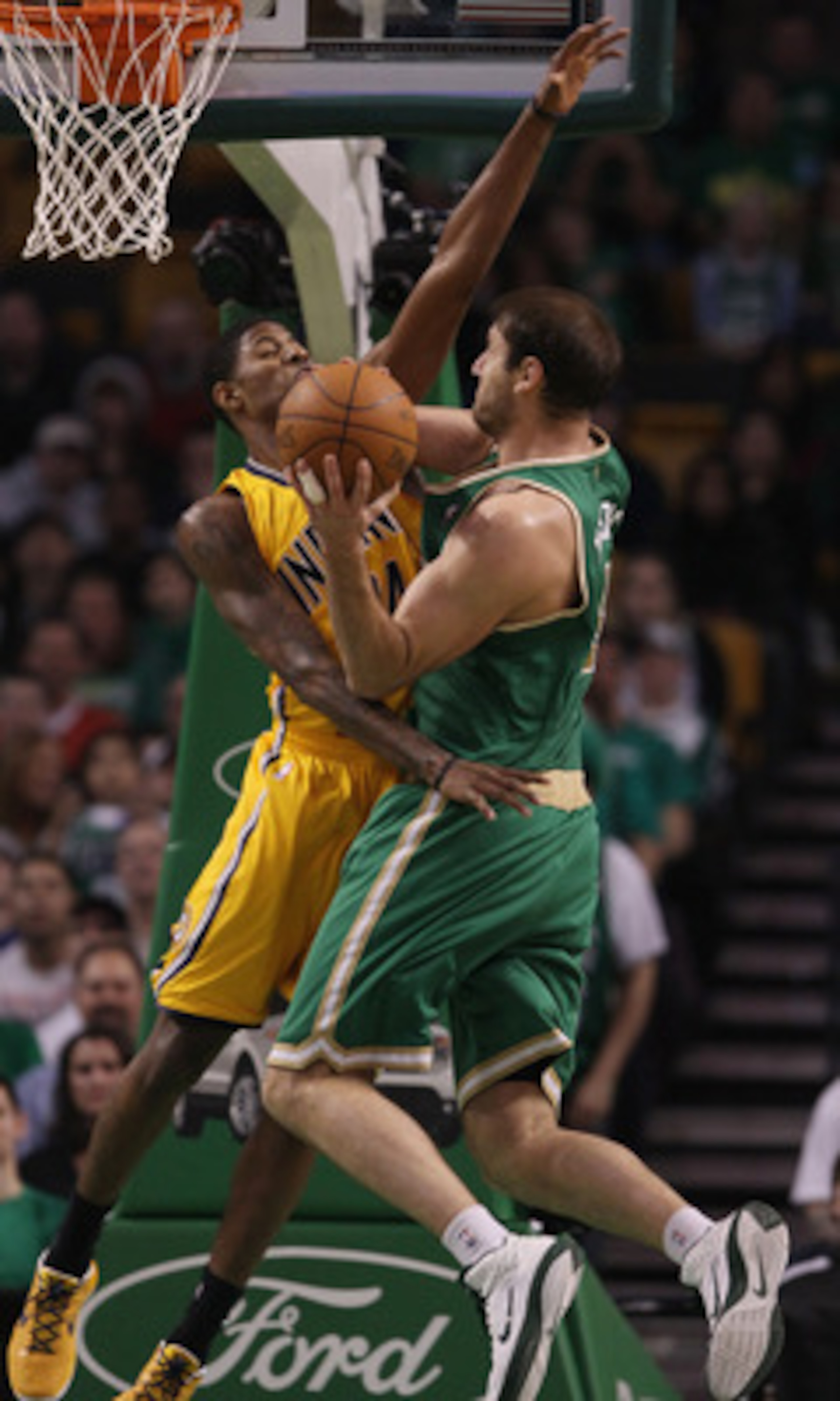 BOSTON, MA - MARCH 16:  Paul George #24 of the Indiana Pacers fouls Nenad Krstic #4 of the Boston Celtics on March 16, 2011 at the TD Garden in Boston, Massachusetts. The Celtics defeated the Indiana Pacers 92-80. NOTE TO USER: User expressly acknowledges