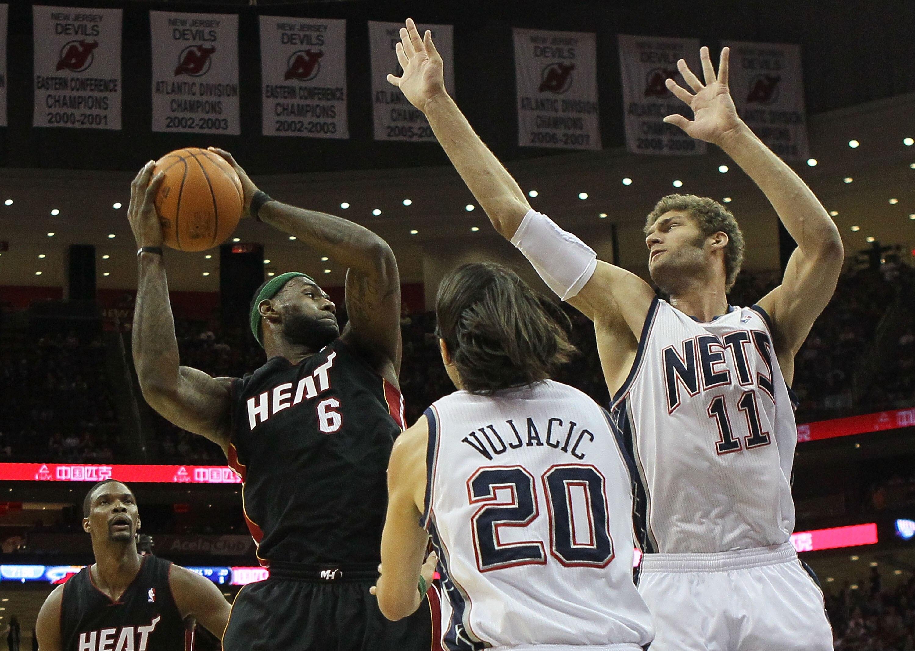 NEWARK, NJ - APRIL 03:  LeBron James #6 of the Miami Heat looks for a teammate against Brook Lopez #11 and Sasha Vujacic #20 of the New Jersey Nets at the Prudential Center on April 3, 2011 in Newark, New Jersey.The Heat defeated the Nets 108-94.NOTE TO U