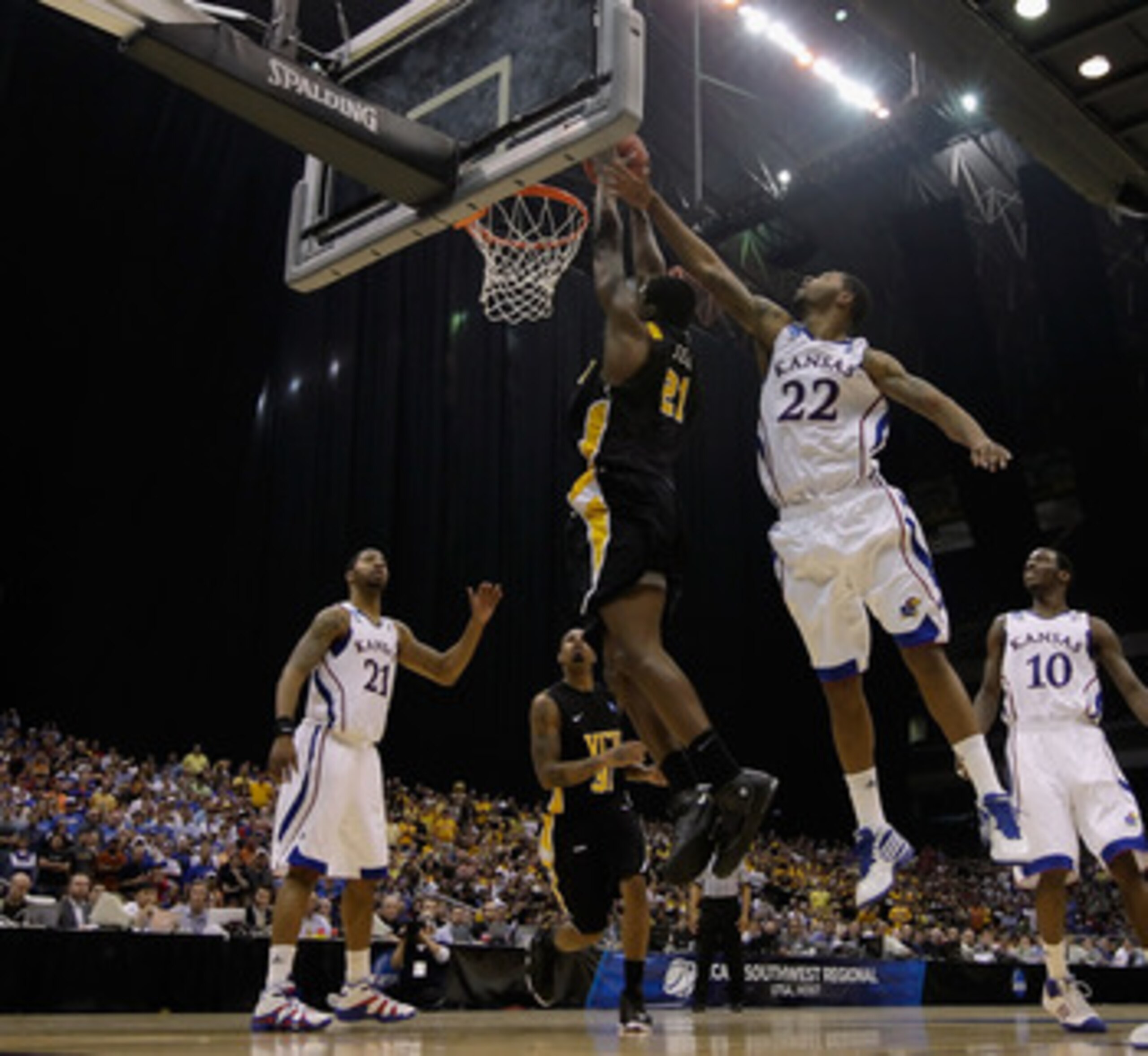 SAN ANTONIO, TX - MARCH 27:  Jamie Skeen #21 of the Virginia Commonwealth Rams goes to the basket against Marcus Morris #22 of the Kansas Jayhawks during the southwest regional final of the 2011 NCAA men's basketball tournament at the Alamodome on March 2