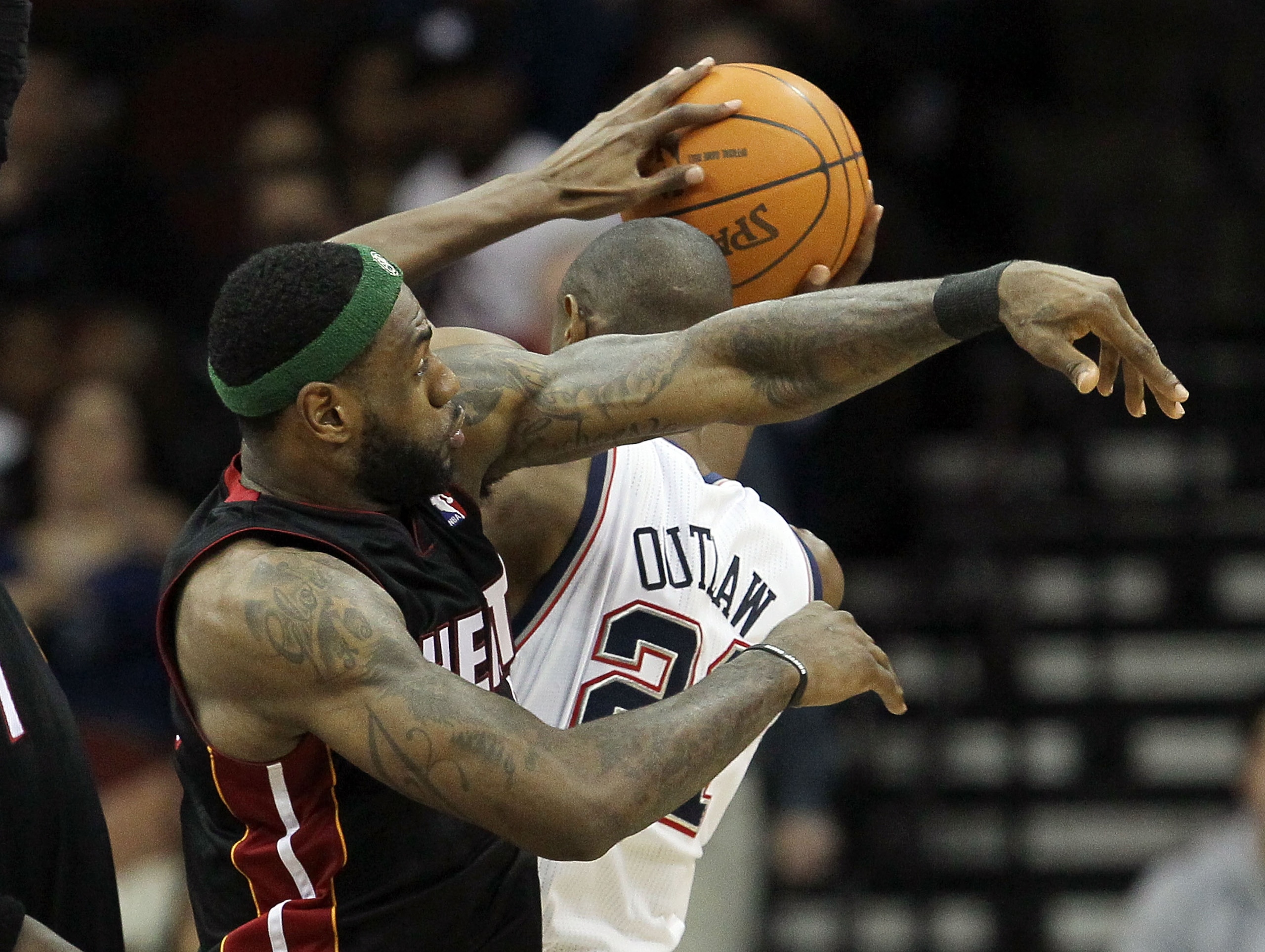 NEWARK, NJ - APRIL 03:  LeBron James #6 of the Miami Heat commits a foul against Travis Outlaw #21 of the New Jersey Nets at the Prudential Center on April 3, 2011 in Newark, New Jersey.The Heat defeated the Nets 108-94.NOTE TO USER: User expressly acknow