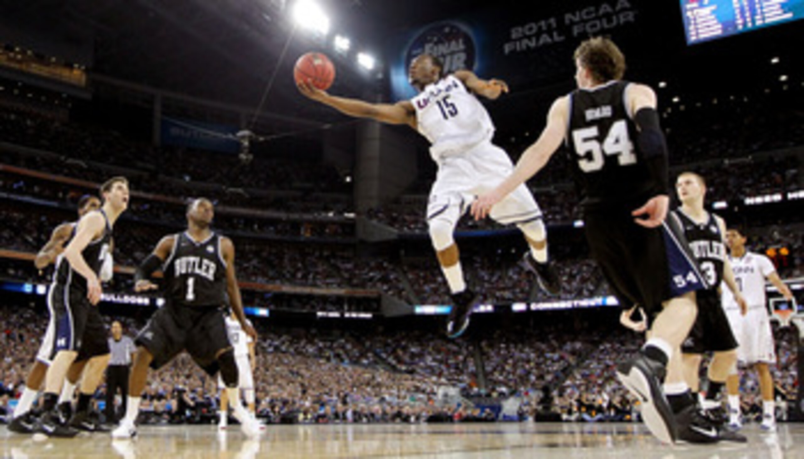 HOUSTON, TX - APRIL 04:  Kemba Walker #15 of the Connecticut Huskies goes to the basket against Matt Howard #54 and Shelvin Mack #1 of the Butler Bulldogs during the National Championship Game of the 2011 NCAA Division I Men's Basketball Tournament at Rel