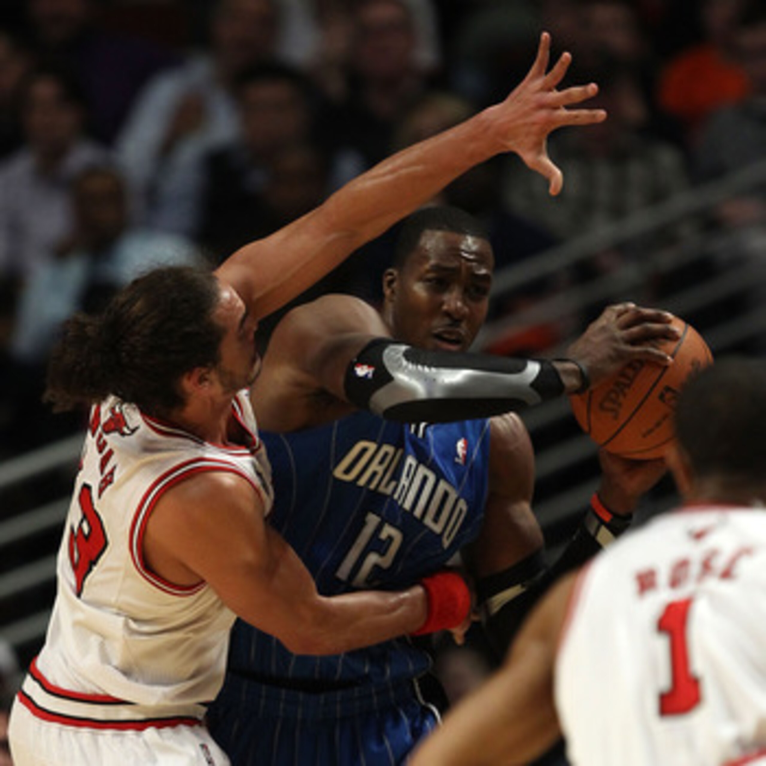 CHICAGO, IL - DECEMBER 01: Dwight Howard #12 of the Orlando Magic looks to pass under pressure from Joakim Noah #13 of the Chicago Bulls at the United Center on December 1, 2010 in Chicago, Illinois. The Magic defeated the Bulls 107-78. NOTE TO USER: User
