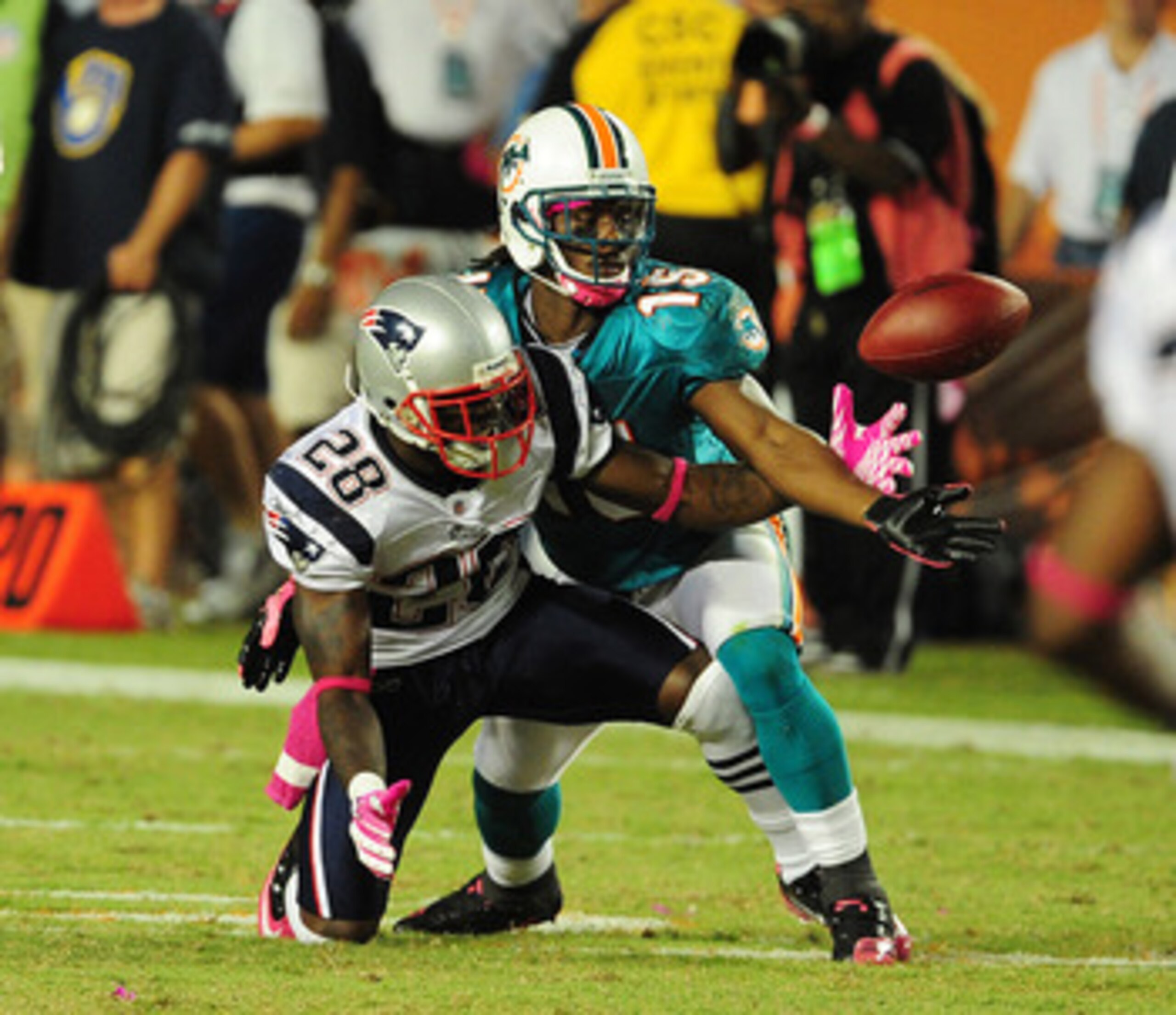 MIAMI - OCTOBER 4: Davone Bess #15 of the Miami Dolphins battles for a pass against Darius Butler #28 of the New England Patriots at Sun Life Field on October 4, 2010 in Miami, Florida. (Photo by Scott Cunningham/Getty Images)