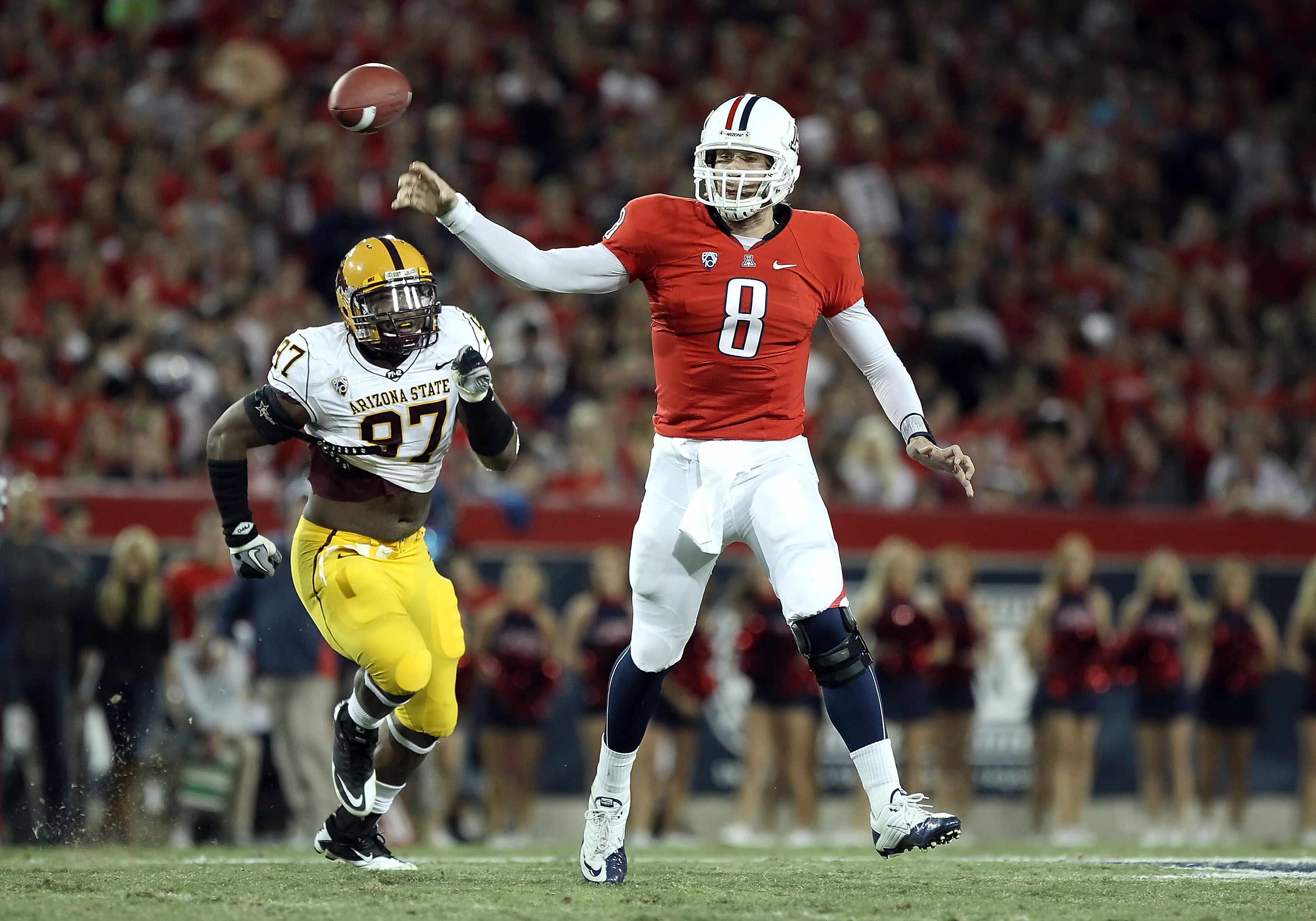 TUCSON, AZ - DECEMBER 02:  Quarterback Nick Foles #8 of the Arizona Wildcats throws a pass under pressure from Junior Onyeali #97 of the Arizona State Sun Devils during the college football game at Arizona Stadium on December 2, 2010 in Tucson, Arizona.