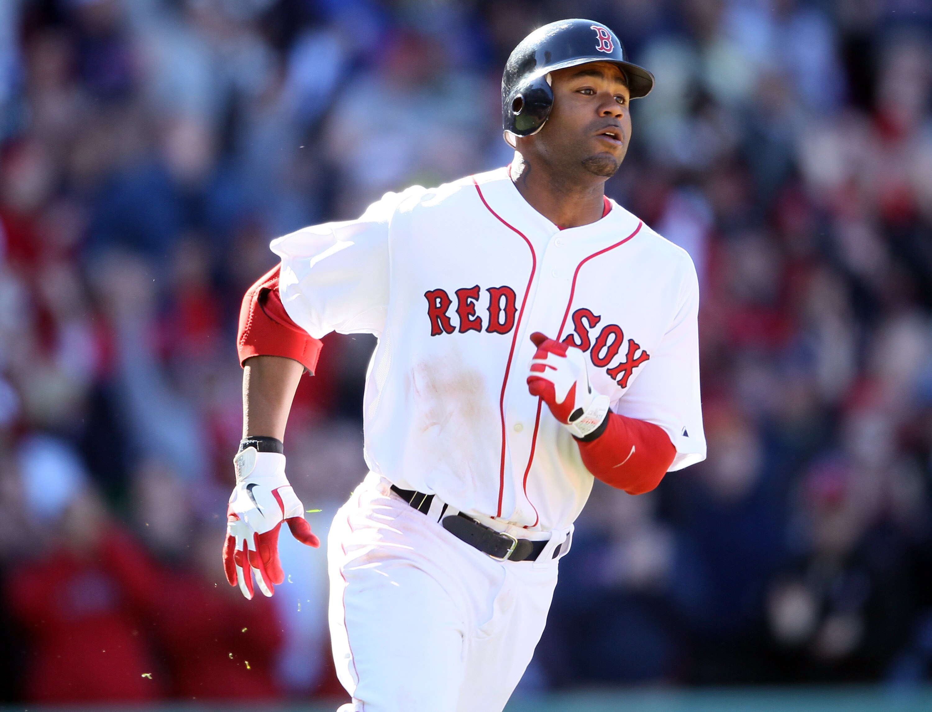 BOSTON, MA - MAY 01:  Carl Crawford #13 of the Boston Red Sox heads for first while Jed Lowrie scores the game winning run in the bottom of the ninth inning against the Seattle Mariners on May 1, 2011 at Fenway Park in Boston, Massachusetts. The Boston Re