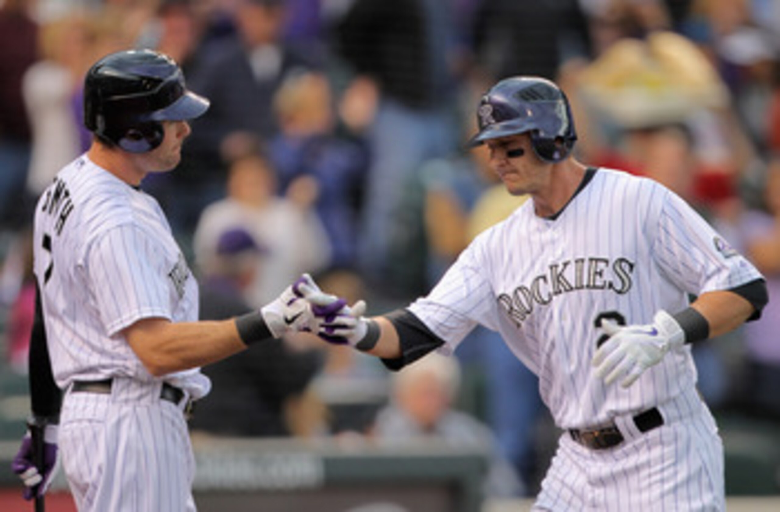 DENVER, CO - MAY 10:  Troy Tulowitzki #2 of the Colorado Rockies is welcomed home after his solo homerun off of starting pitcher Mike Pelfrey #34 of the New York Mets by Seth Smith #7 of the Colorado Rockies in the second inning at Coors Field on May 10, 