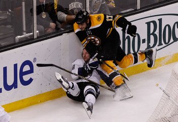 BOSTON, MA - MAY 14:  Adam Hall #18 of the Tampa Bay Lightning is checked by Milan Lucic #17 of the Boston Bruins in the third period of Game One of the Eastern Conference Finals during the 2011 NHL Stanley Cup Playoffs at TD Garden on May 14, 2011 in Bos