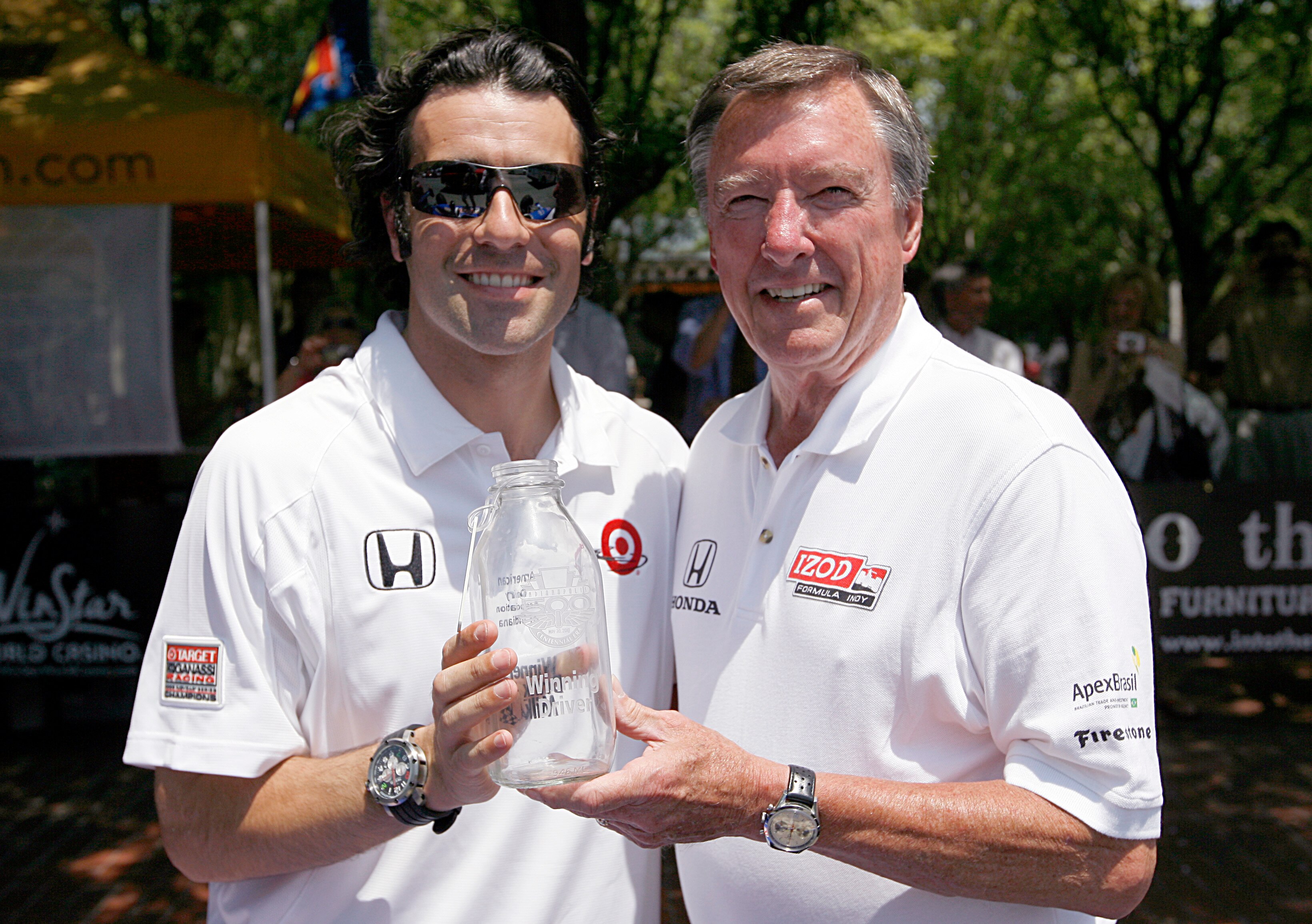 DALLAS, TEXAS - JUNE 2:  Dario Franchitti, winner of the 2010 Indy 500, and Johnny Rutherford, three-time Indy 500 winner, display the winner's milk bottle as they arrive at the Indy 500 Champion's Luncheon hosted by Texas Motor Speedway June 2, 2010 in F