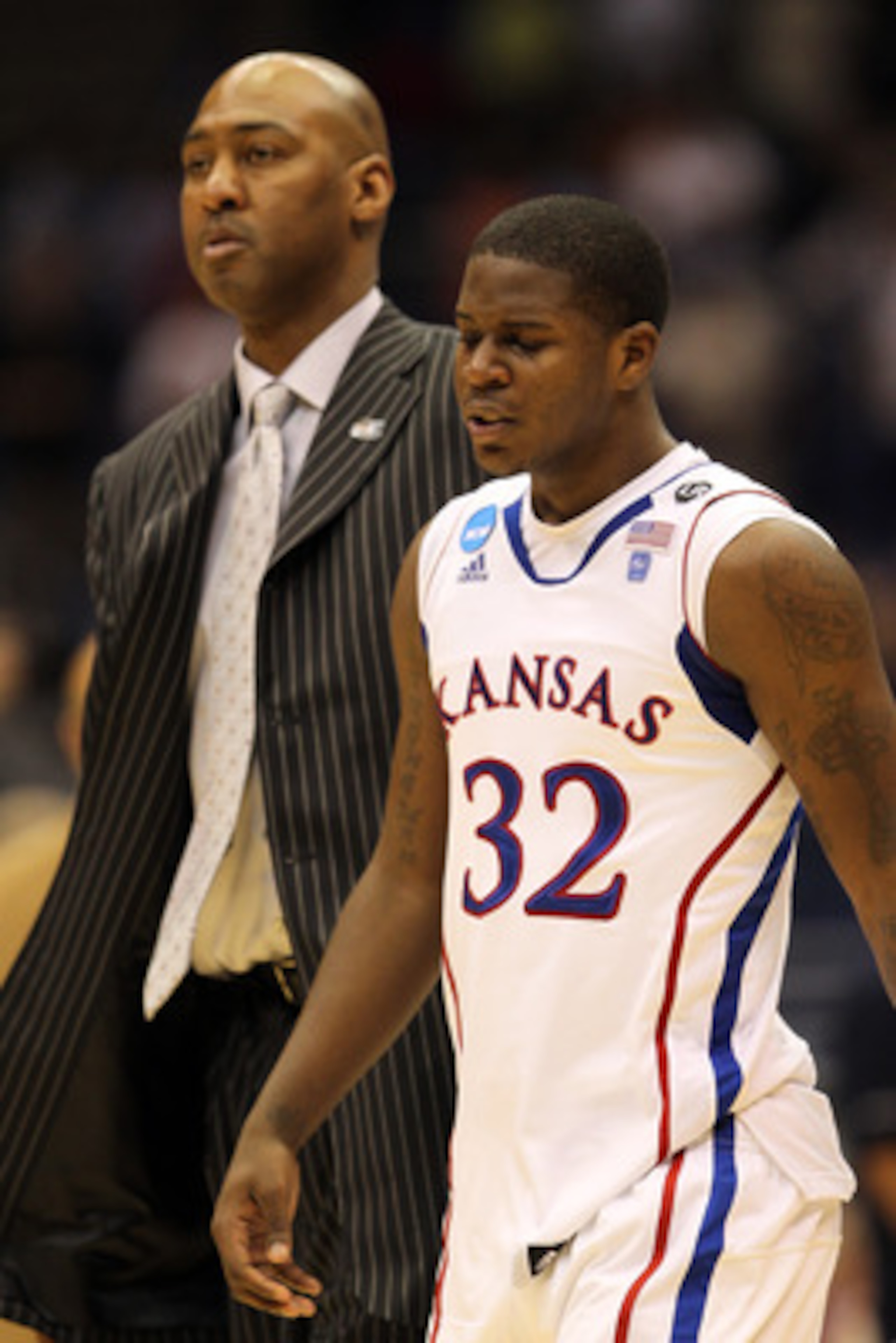 SAN ANTONIO, TX - MARCH 27:  Josh Selby #32 of the Kansas Jayhawks and assistant coach Danny Manning react after the southwest regional final of the 2011 NCAA men's basketball tournament against the Virginia Commonwealth Rams at the Alamodome on March 27,