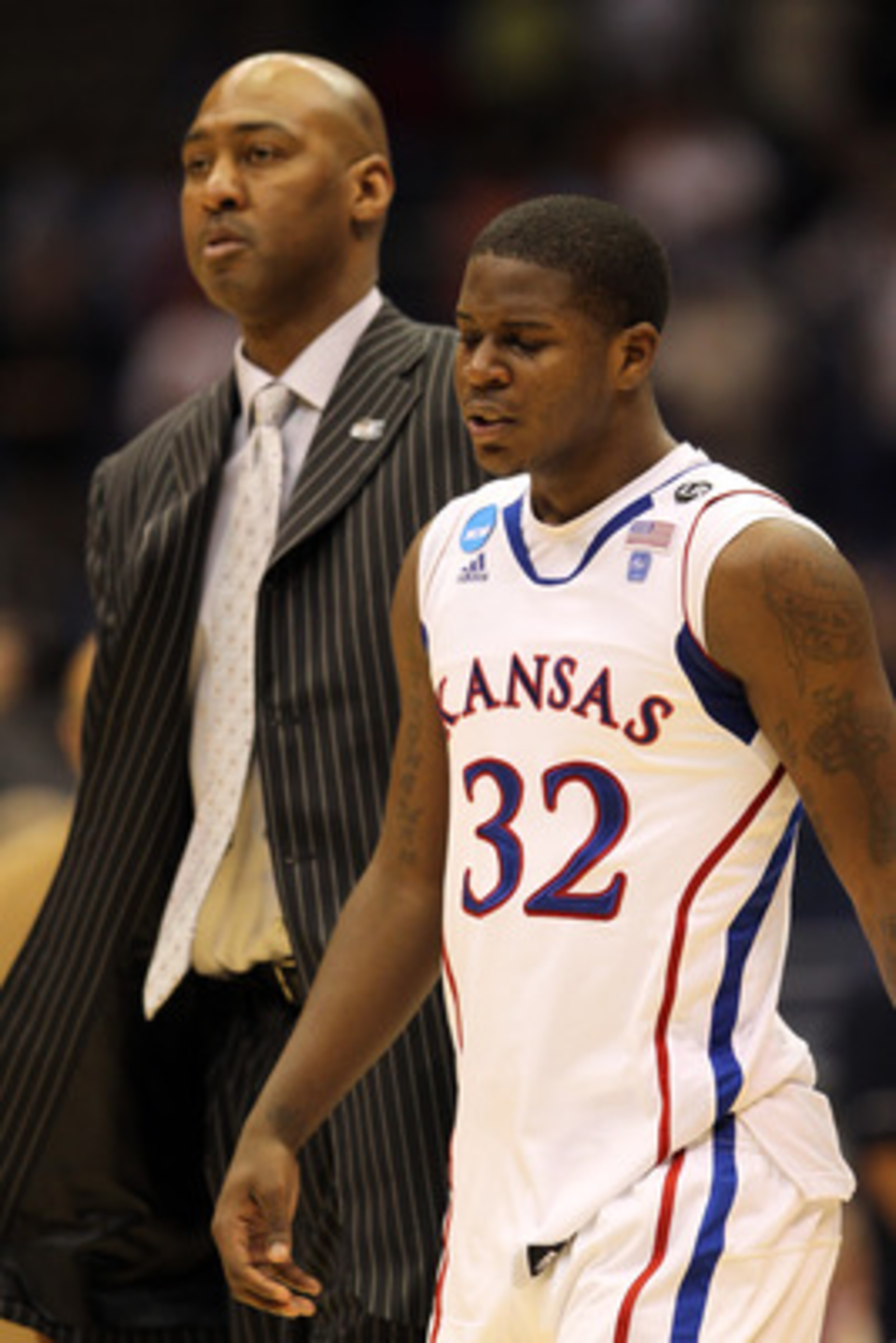 SAN ANTONIO, TX - MARCH 27:  Josh Selby #32 of the Kansas Jayhawks and assistant coach Danny Manning react after the southwest regional final of the 2011 NCAA men's basketball tournament against the Virginia Commonwealth Rams at the Alamodome on March 27,