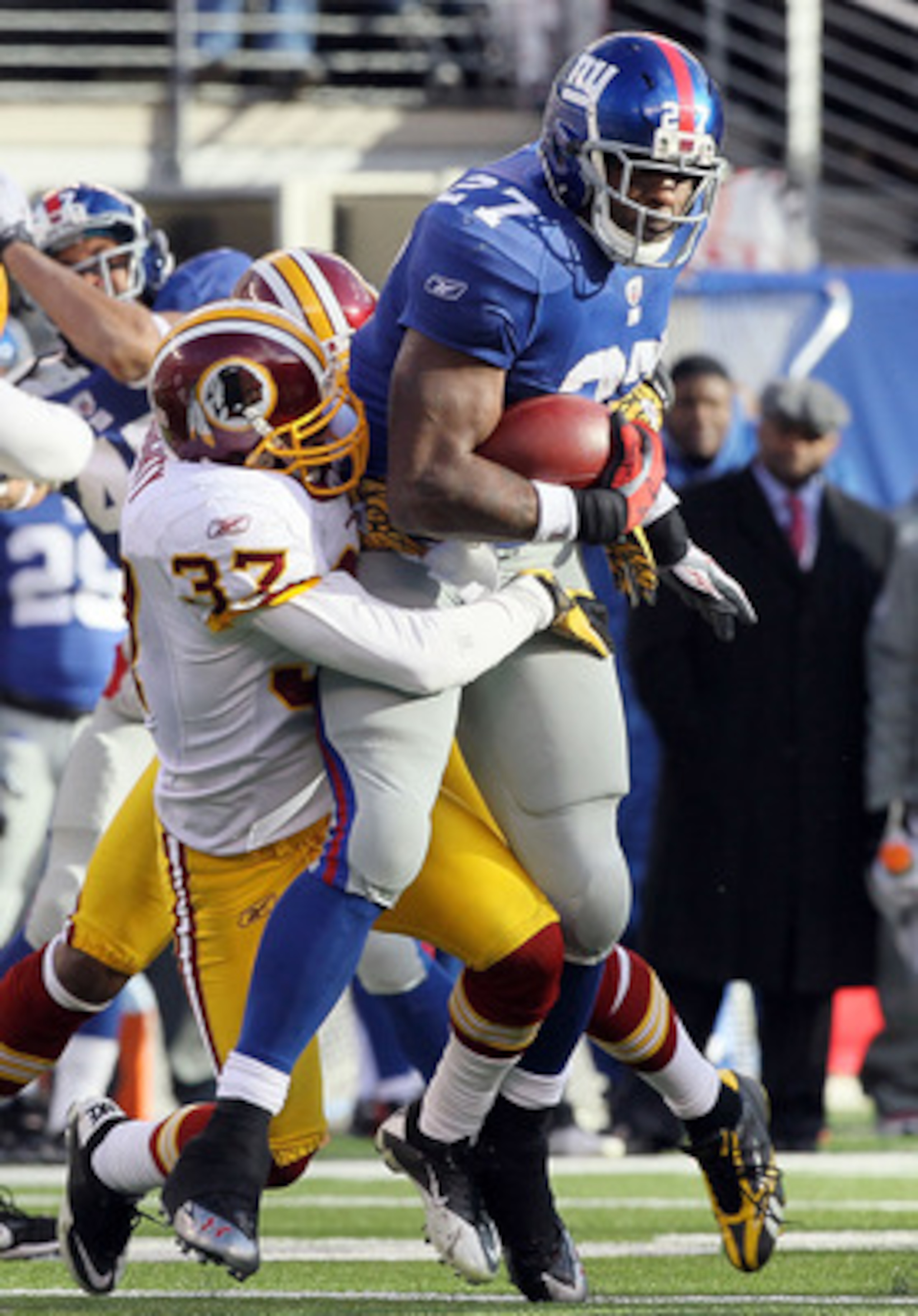 EAST RUTHERFORD, NJ - DECEMBER 05: Reed Doughty #37 of the Washington Redskins attempts a tackle against Brandon Jacobs #27 of the New York Giants on December 5, 2010 at the New Meadowlands Stadium in East Rutherford, New Jersey.  (Photo by Jim McIsaac/Ge