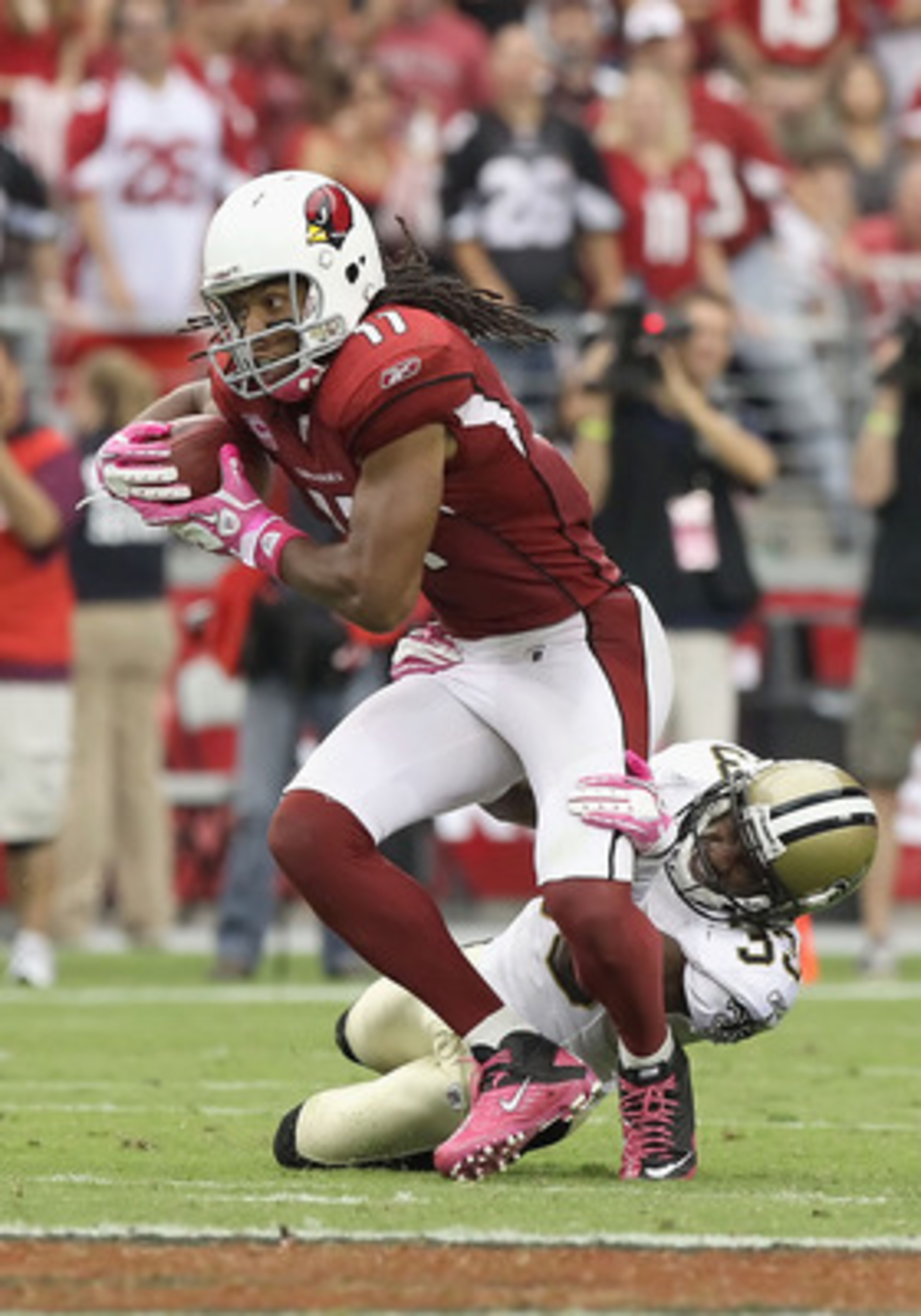 GLENDALE, AZ - OCTOBER 10: Wide receiver Larry Fitzgerald #11 of the Arizona Cardinals runs with the football after a reception against the New Orleans Saints during the NFL game at the University of Phoenix Stadium on October 10, 2010 in Glendale, Arizo GLENDALE, AZ - OCTOBER 10: Wide receiver Larry Fitzgerald #11 of the Arizona Cardinals runs with the football after a reception against the New Orleans Saints during the NFL game at the University of Phoenix Stadium on October 10, 2010 in Glendale, Arizo