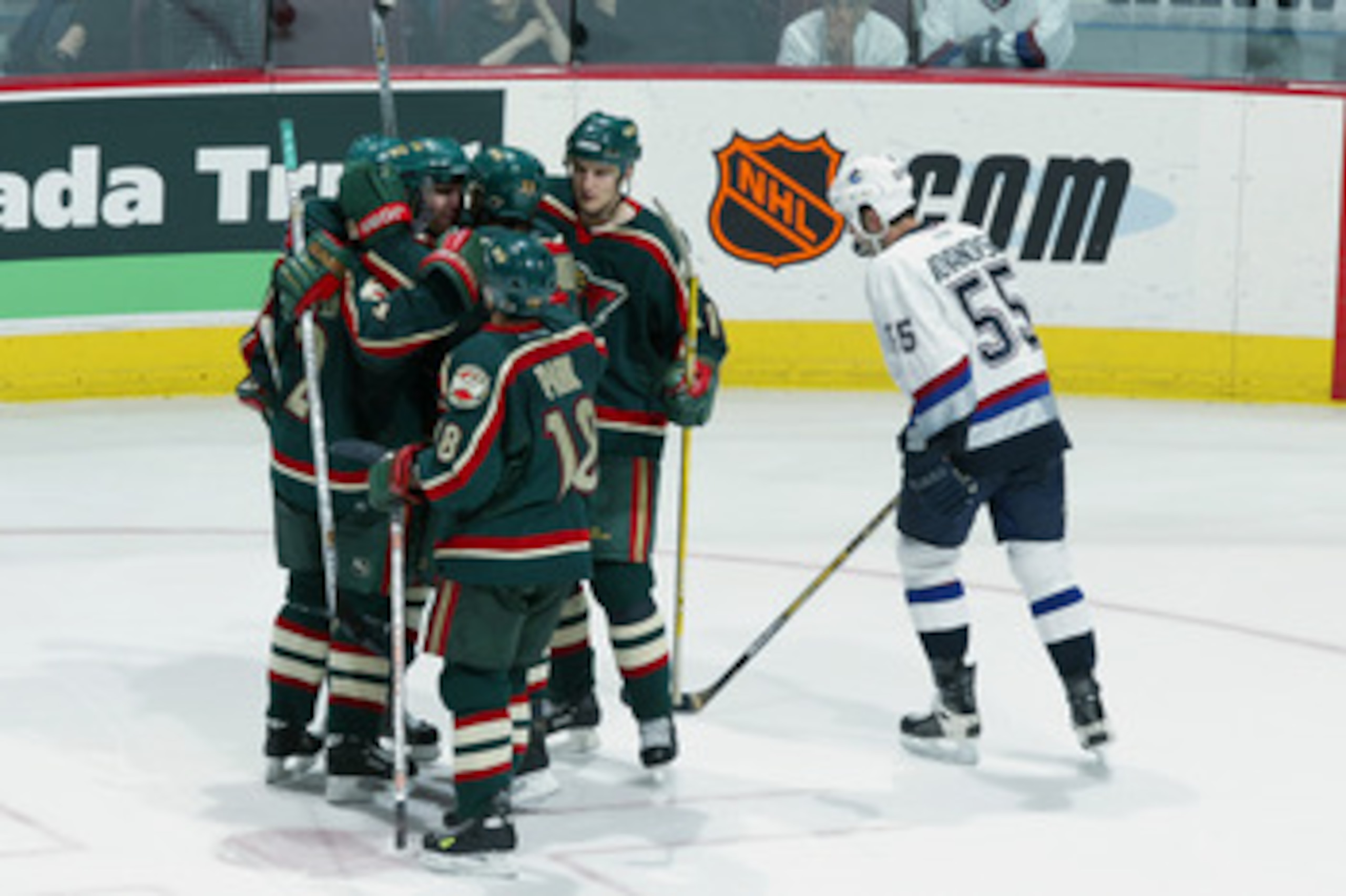 VANCOUVER - MAY 8:  Members of the Minnesota Wild gather around teammate Pascal Dupuis #11 to celebrate his goal as Ed Jovanovski #55 of the Vancouver Canucks skates by during game seven in the 2002 Western Conference semifinals of the Stanley Cup playoff