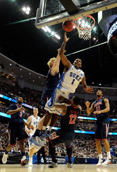 ANAHEIM, CA - MARCH 24:  Kyrie Irving #1 of the Duke Blue Devils draws contact against Kyryl Natyazhko #1 and Lamont Jones #12 of the Arizona Wildcats during the west regional semifinal of the 2011 NCAA men's basketball tournament at the Honda Center on M