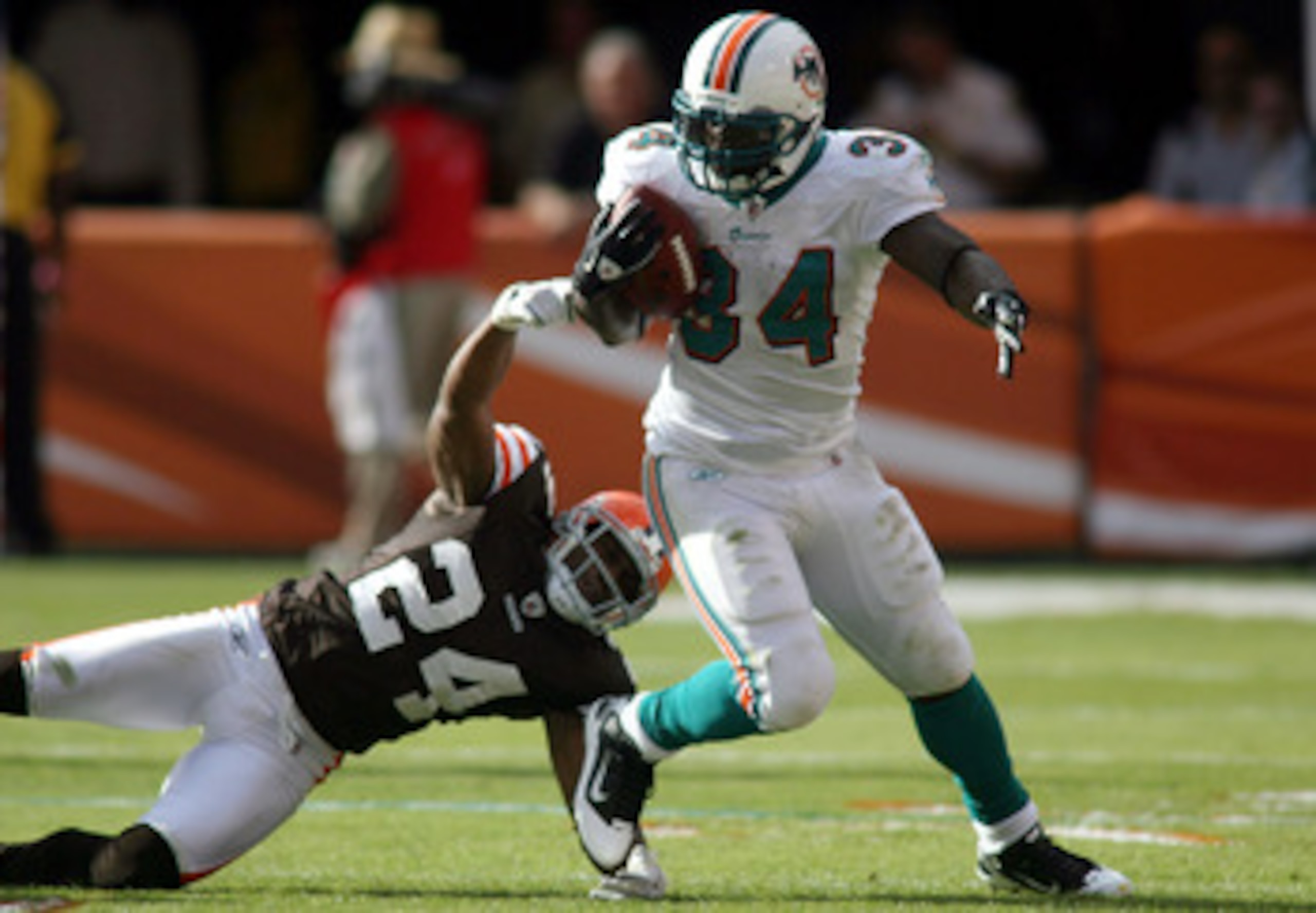 MIAMI - DECEMBER 05:  Running back Ricky Williams #34 of the Miami Dolphins is brought down by Sheldon Brown #24 of the Cleveland Browns at Sun Life Stadium on December 5, 2010 in Miami, Florida.  (Photo by Marc Serota/Getty Images)